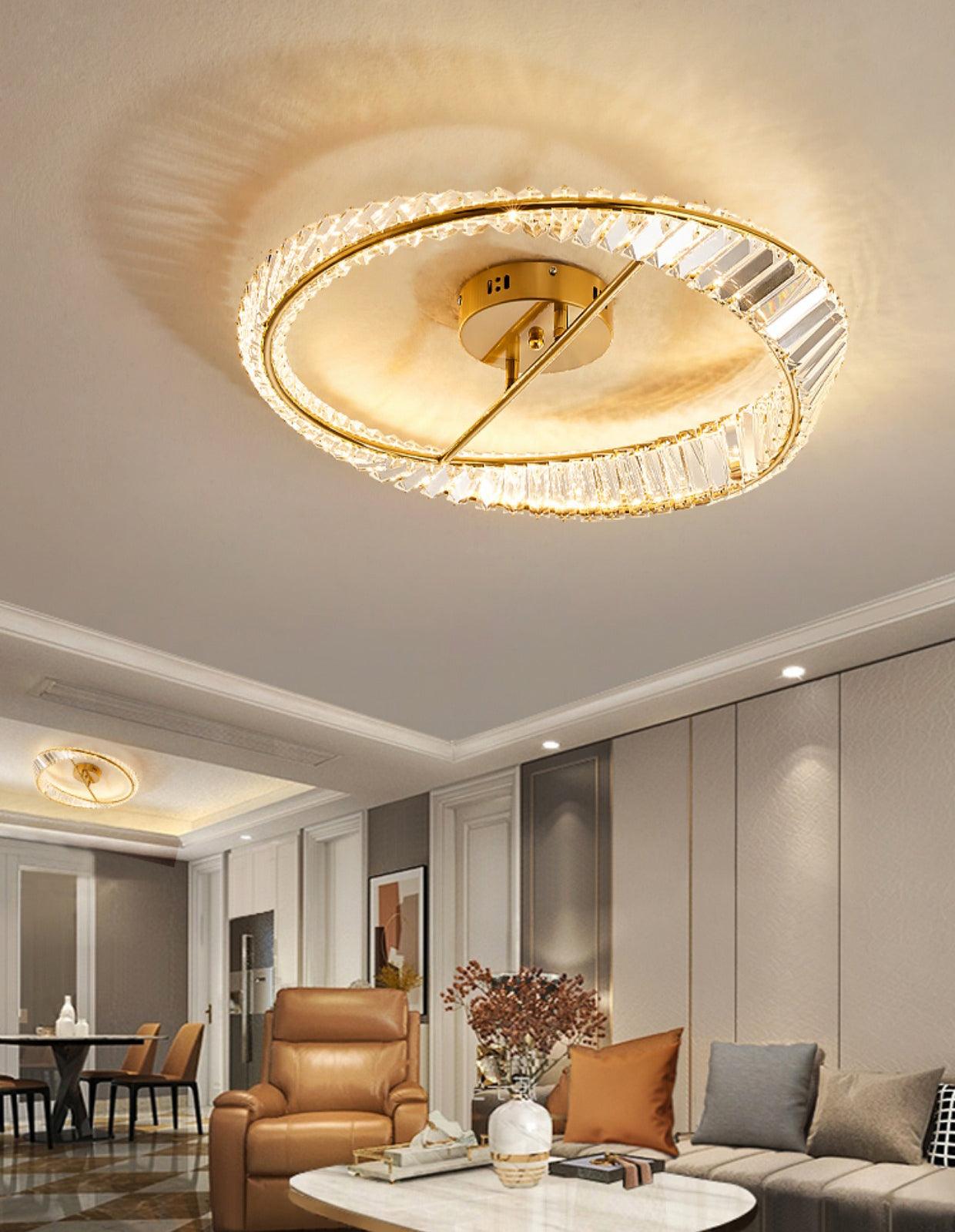 Gold-tone ring ceiling light above a living area with a second ceiling light in the distant dining area