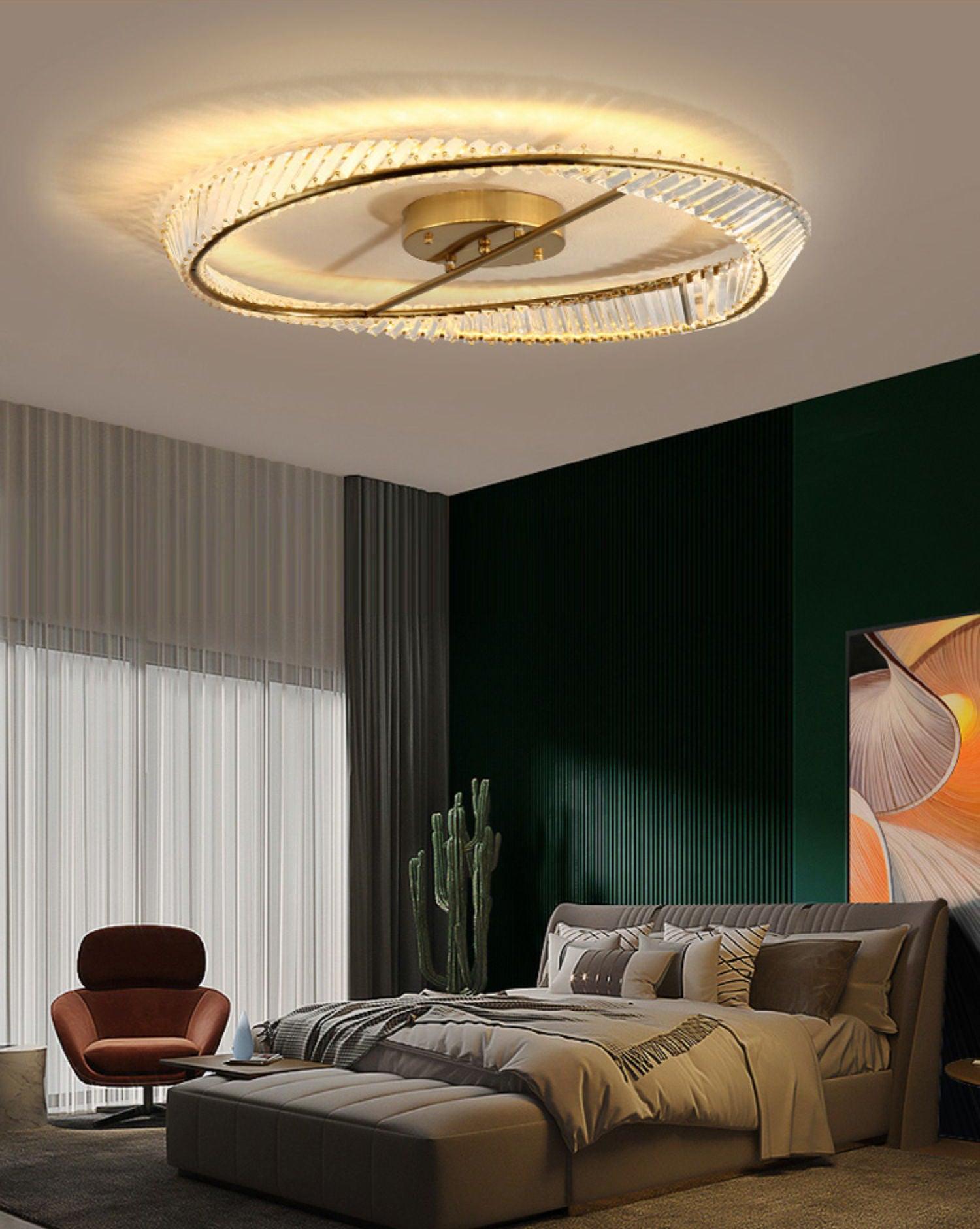 Glass ring ceiling light above a bed beside a dark green wall and brown lounge chair