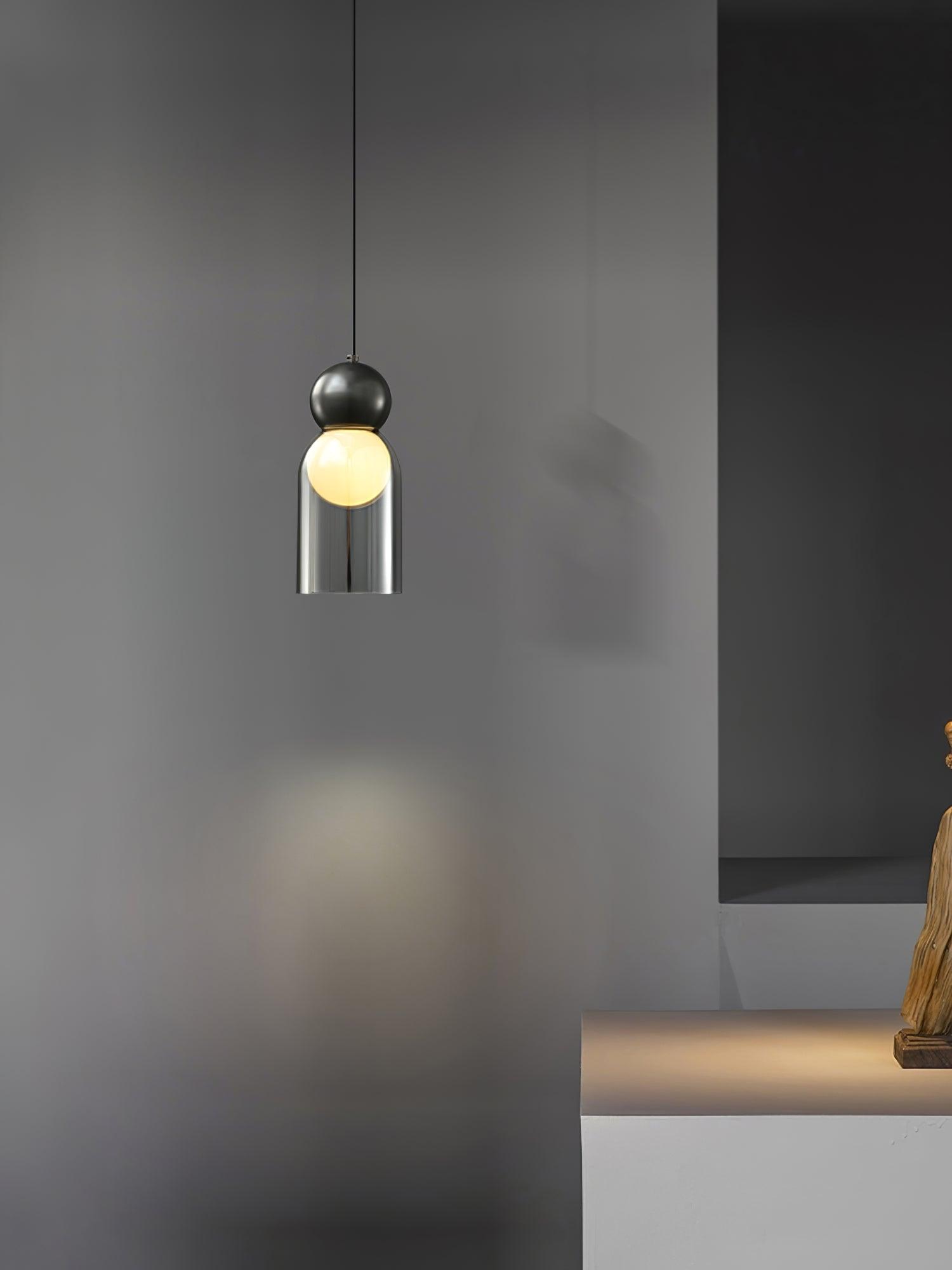 Black glass-cylinder Dani pendant beside a wall