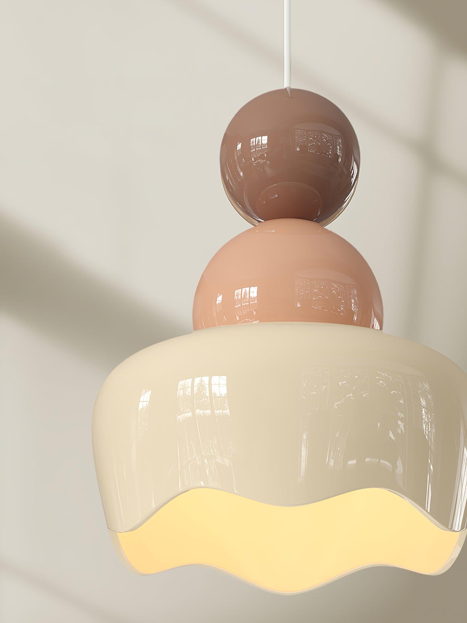 Brown sphere and pink middle above a cream scalloped shade