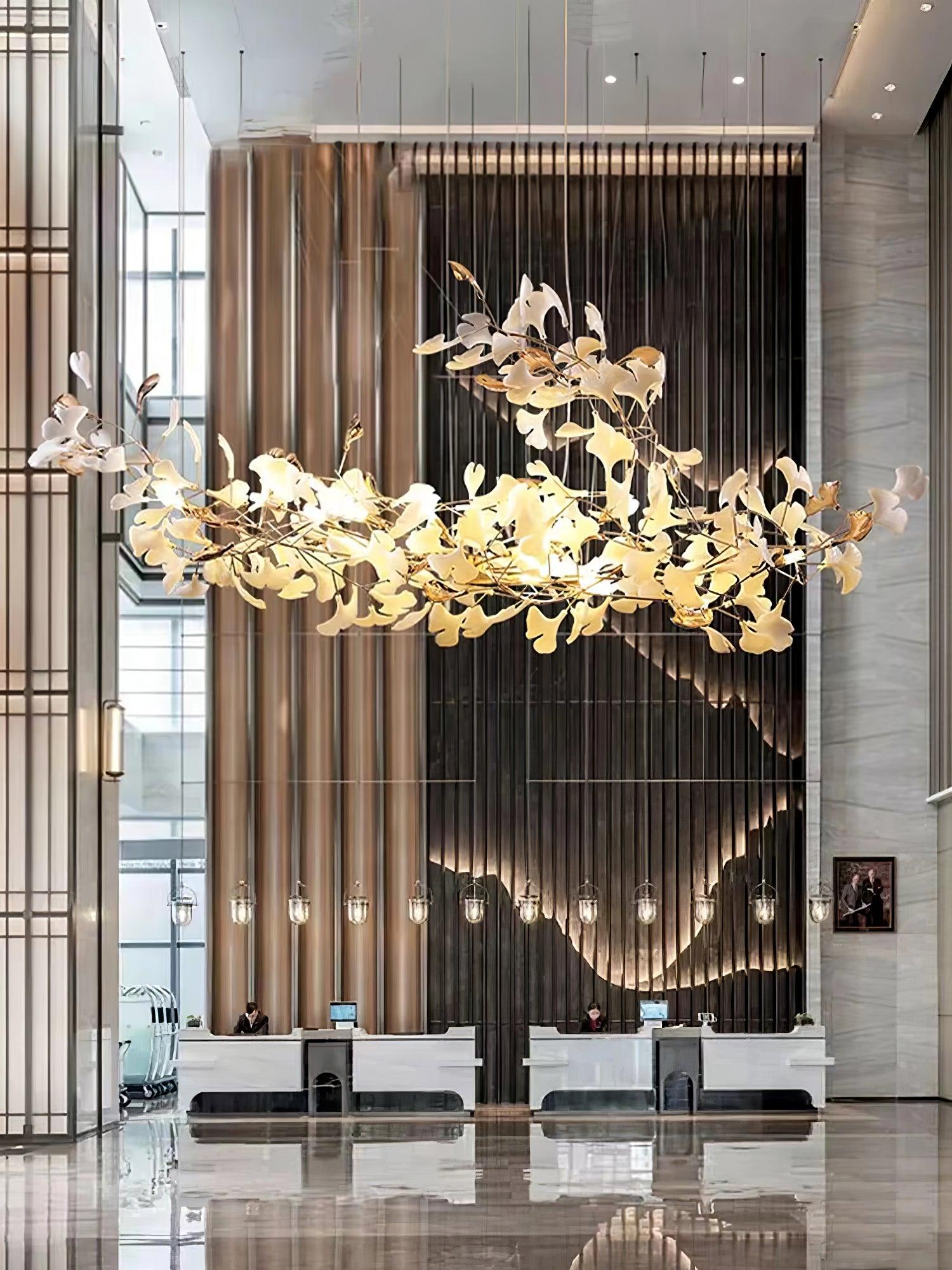 Gold-and-white ginkgo leaf installation above a reception counter against dark slats and a wavy sculptural backdrop