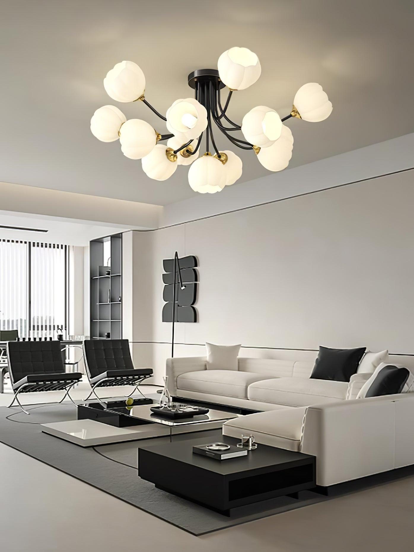 Black Pumpkin ceiling light with gold-colour fittings and white glass shades above a white sectional sofa