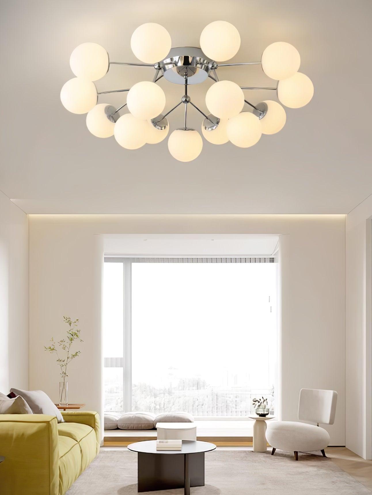Chrome globe ceiling light above a mustard sofa, white armchair and round black coffee table near a broad window seat