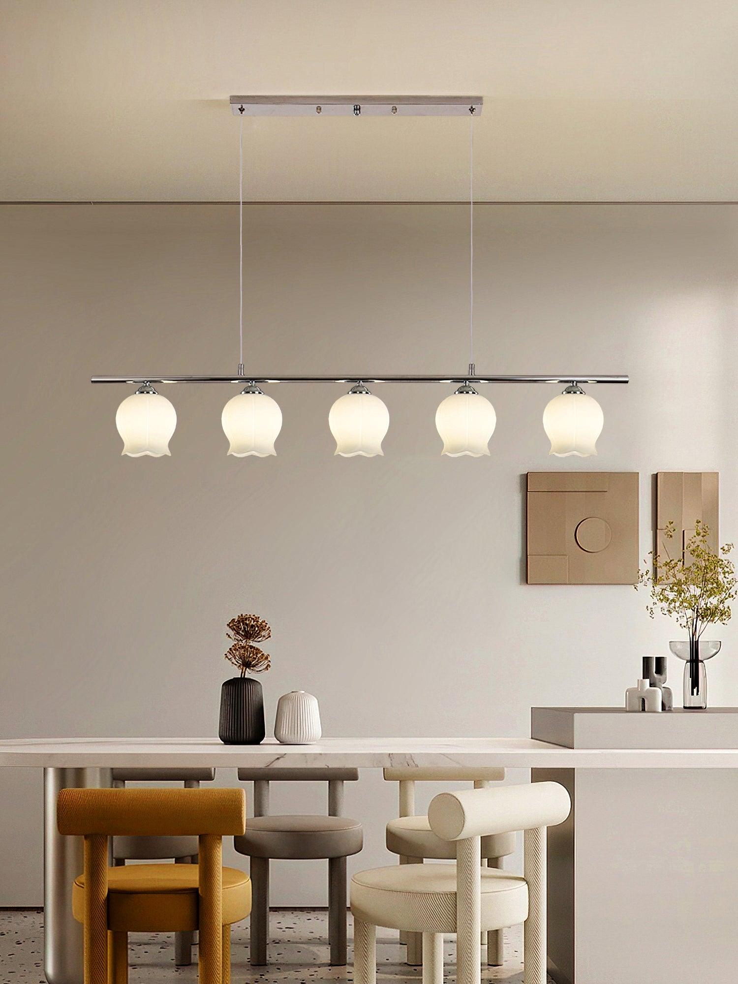 Five white floral glass shades on a chrome bar in a dining room