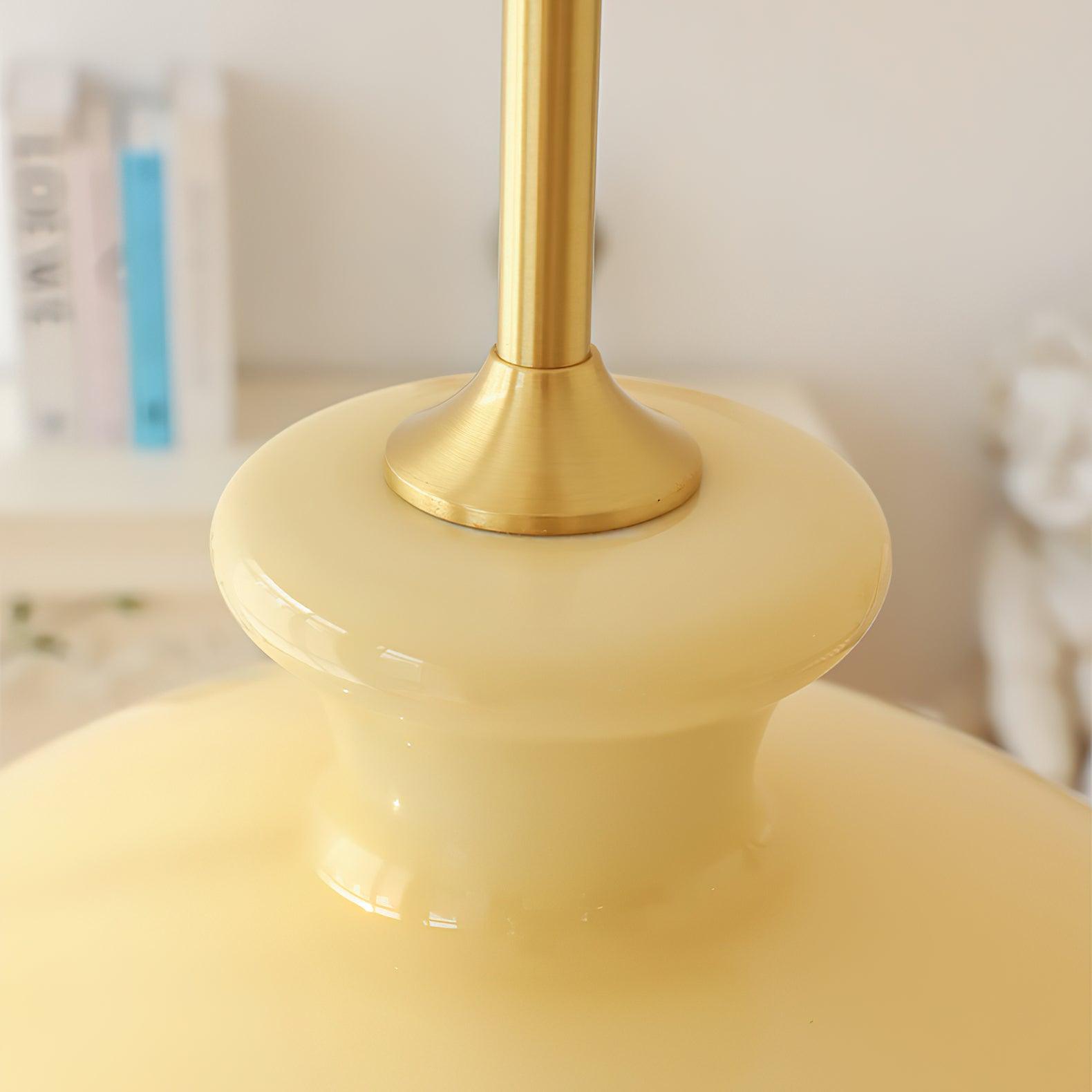 Upper-neck detail of yellow glass, gold-tone rod and flared connector plate