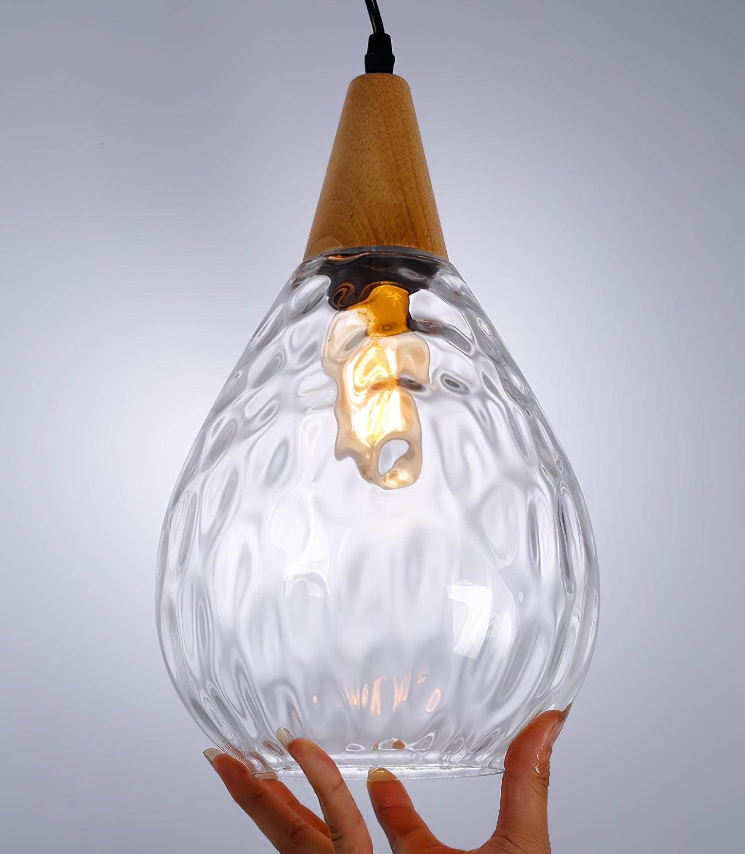 Textured clear glass pendant with illuminated bulb