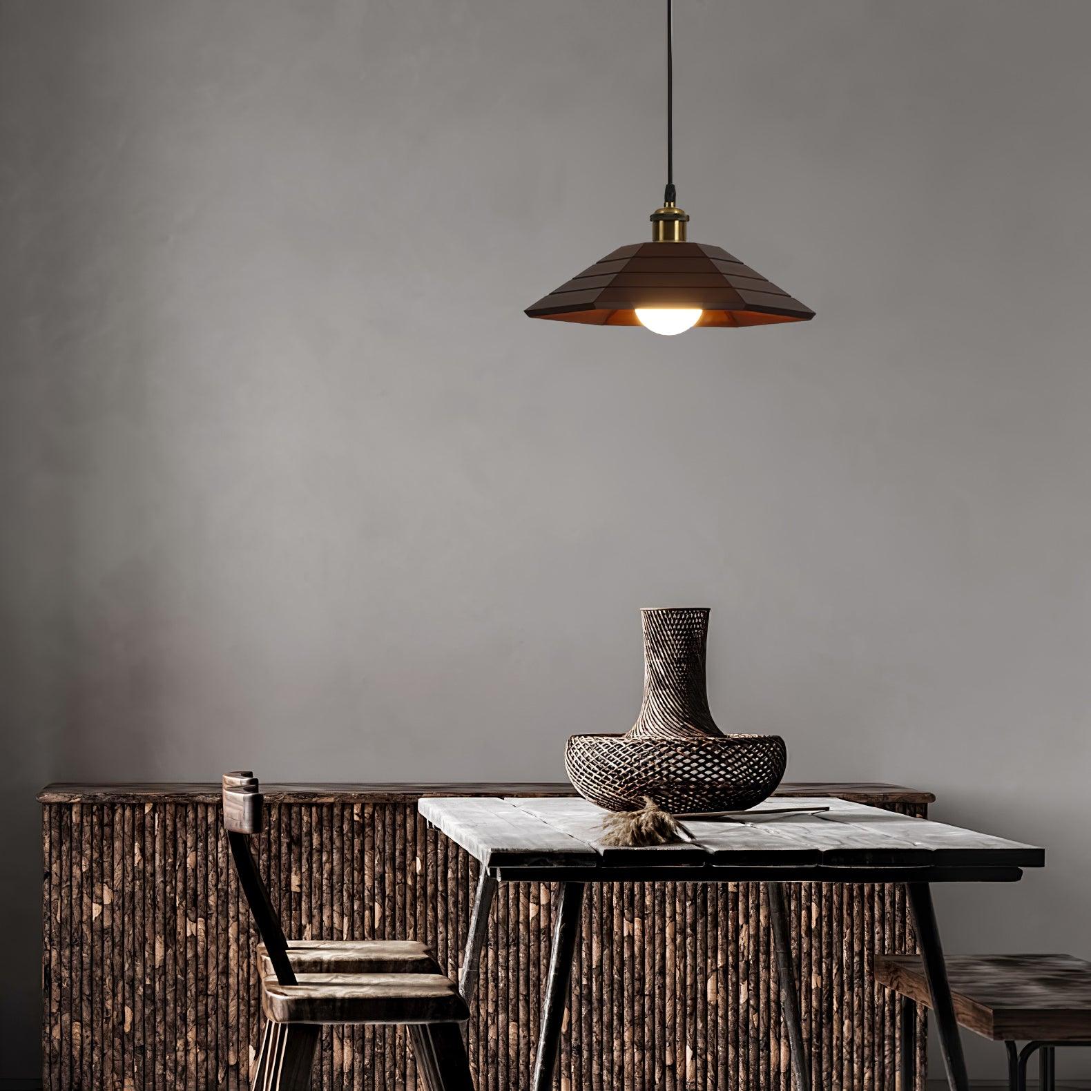 Dark wood pendant above a rustic wooden table with woven vase, wooden chairs and a slatted cabinet