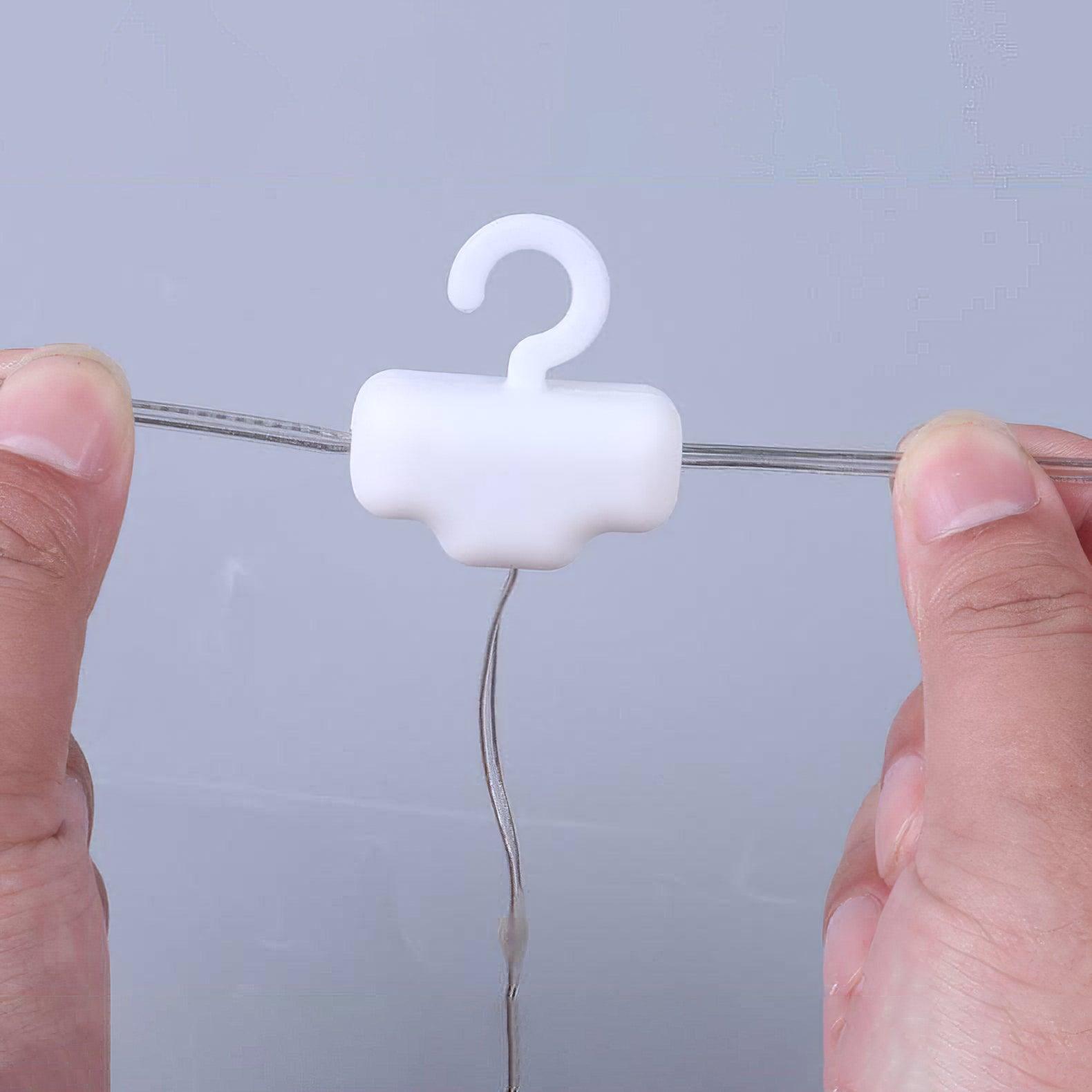 White hanging hook on the horizontal curtain-light wire