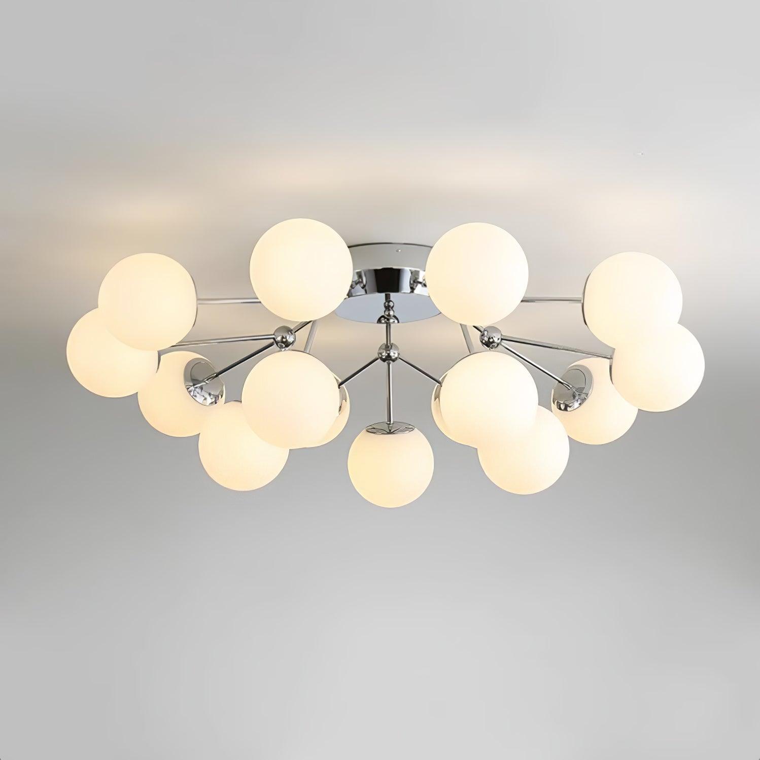 Close low-angle view of warm-lit white globes on chrome branching rods below a reflective round ceiling canopy