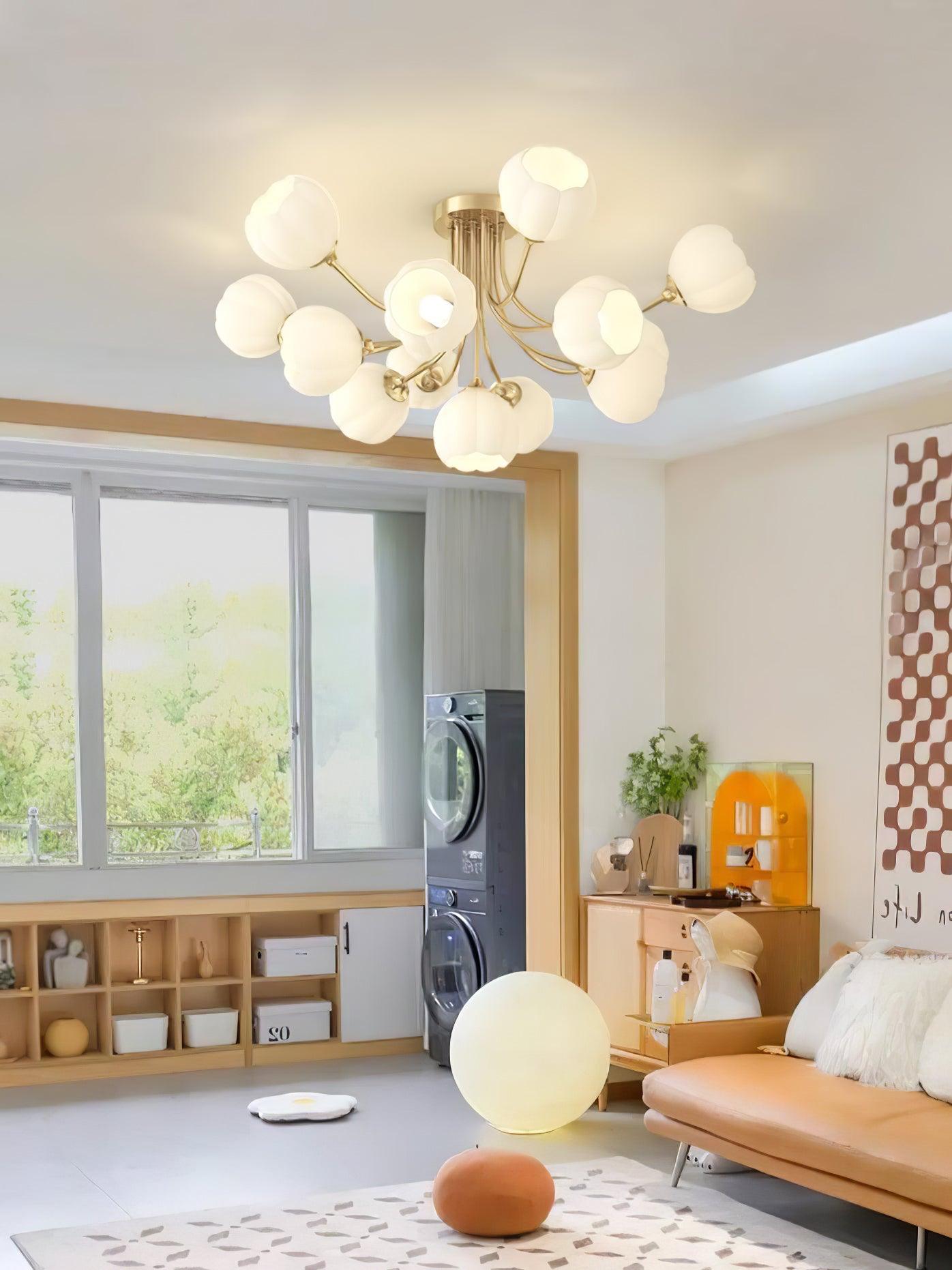 Pumpkin brass-colour branching ceiling light above a peach sofa beside a separate globe floor lamp