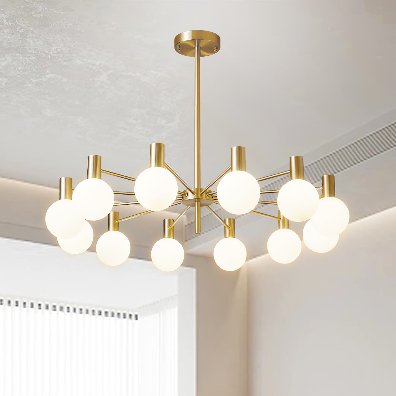 Upward view of twelve lit white globes on gold-tone arms beneath a pale ceiling with cove lighting and an air grille.