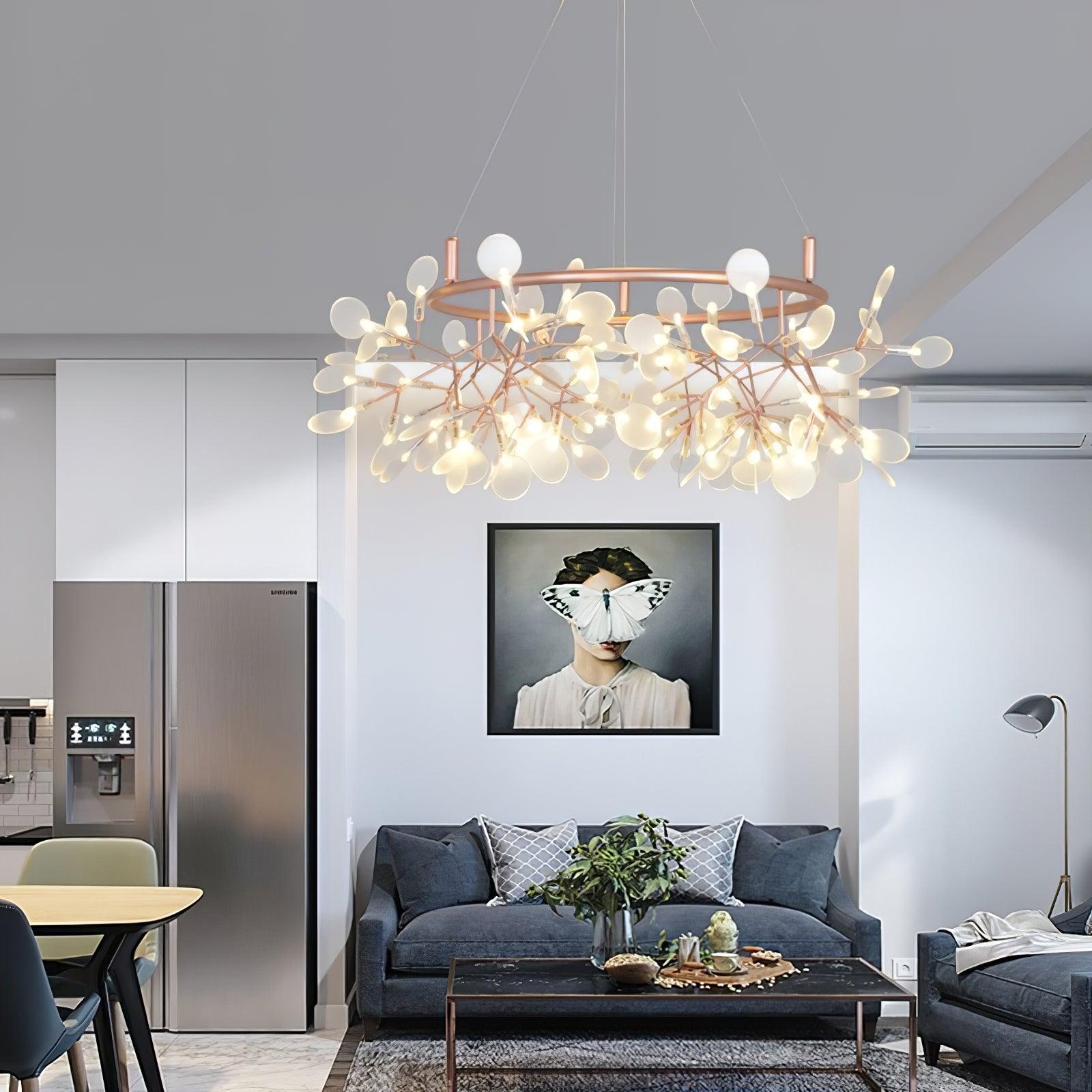 Small rose-copper leaf ring chandelier over a dark grey sofa below butterfly portrait artwork