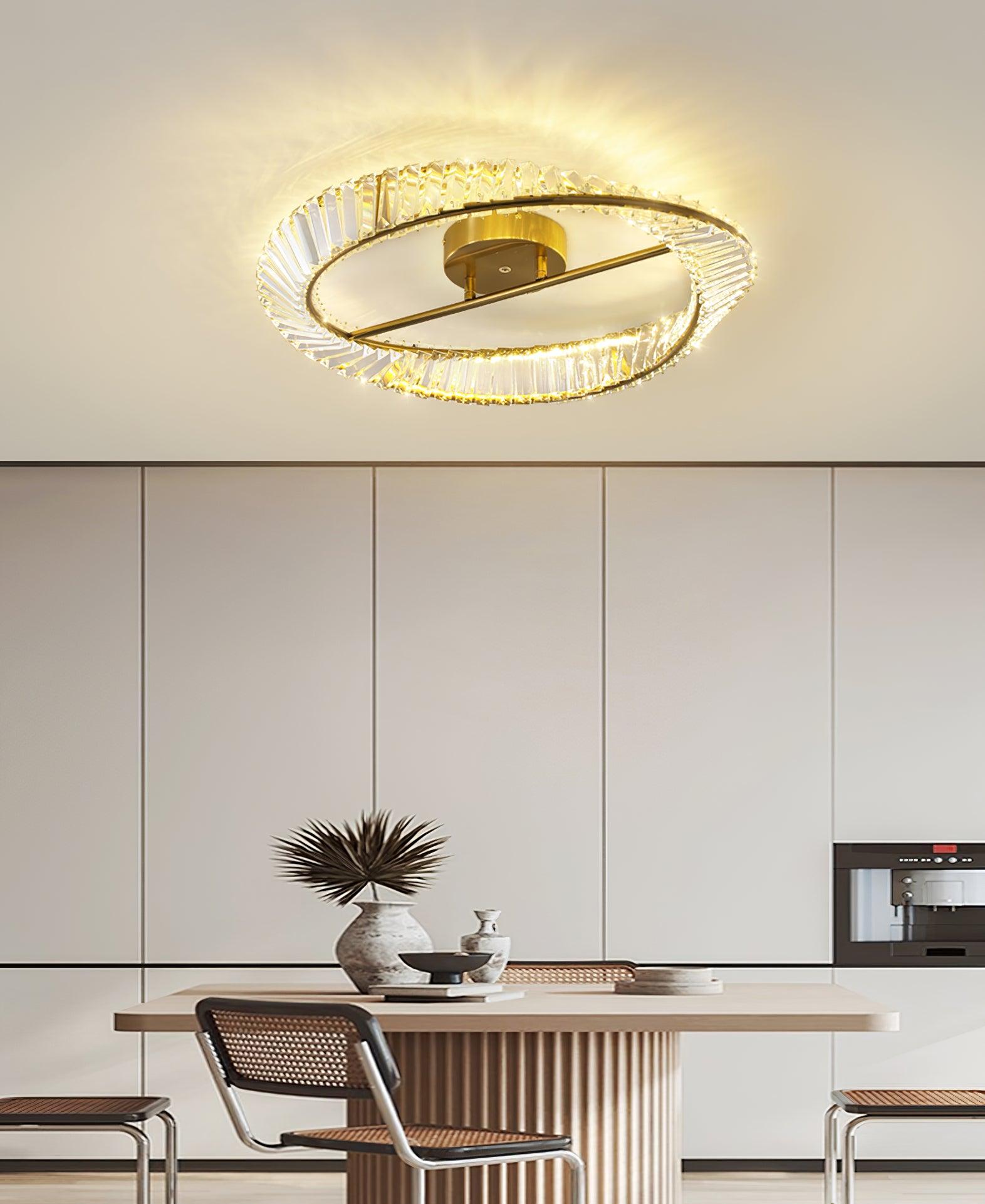 Gold-tone glass ring light above a wood dining table and woven-back chairs