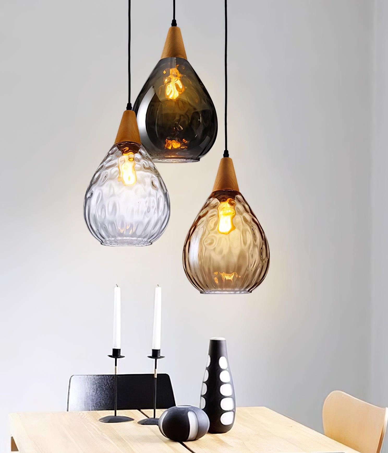 Three separate Besnier pendants in clear, amber and smoky glass