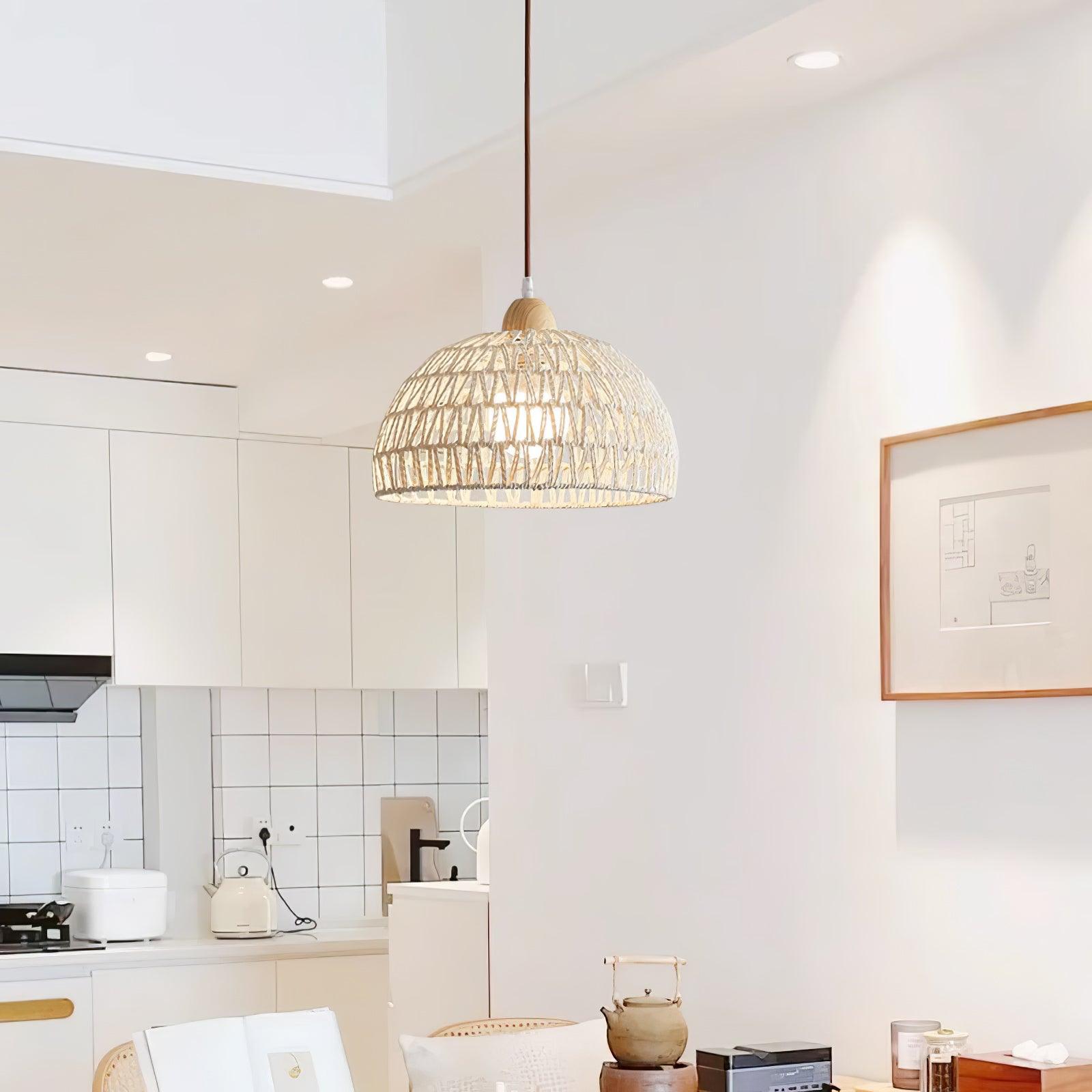Wide kitchen and dining view of a single woven dome pendant with a kettle and framed artwork
