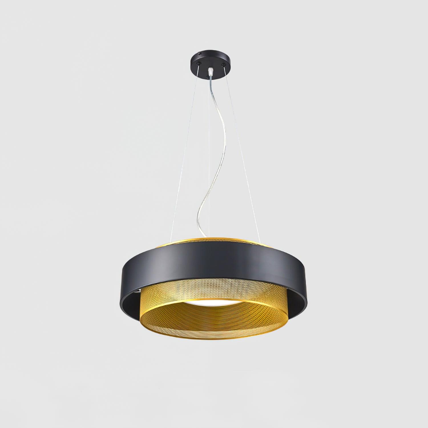 Lit black and gold-tone layered drum pendant with a central white diffuser on pale grey