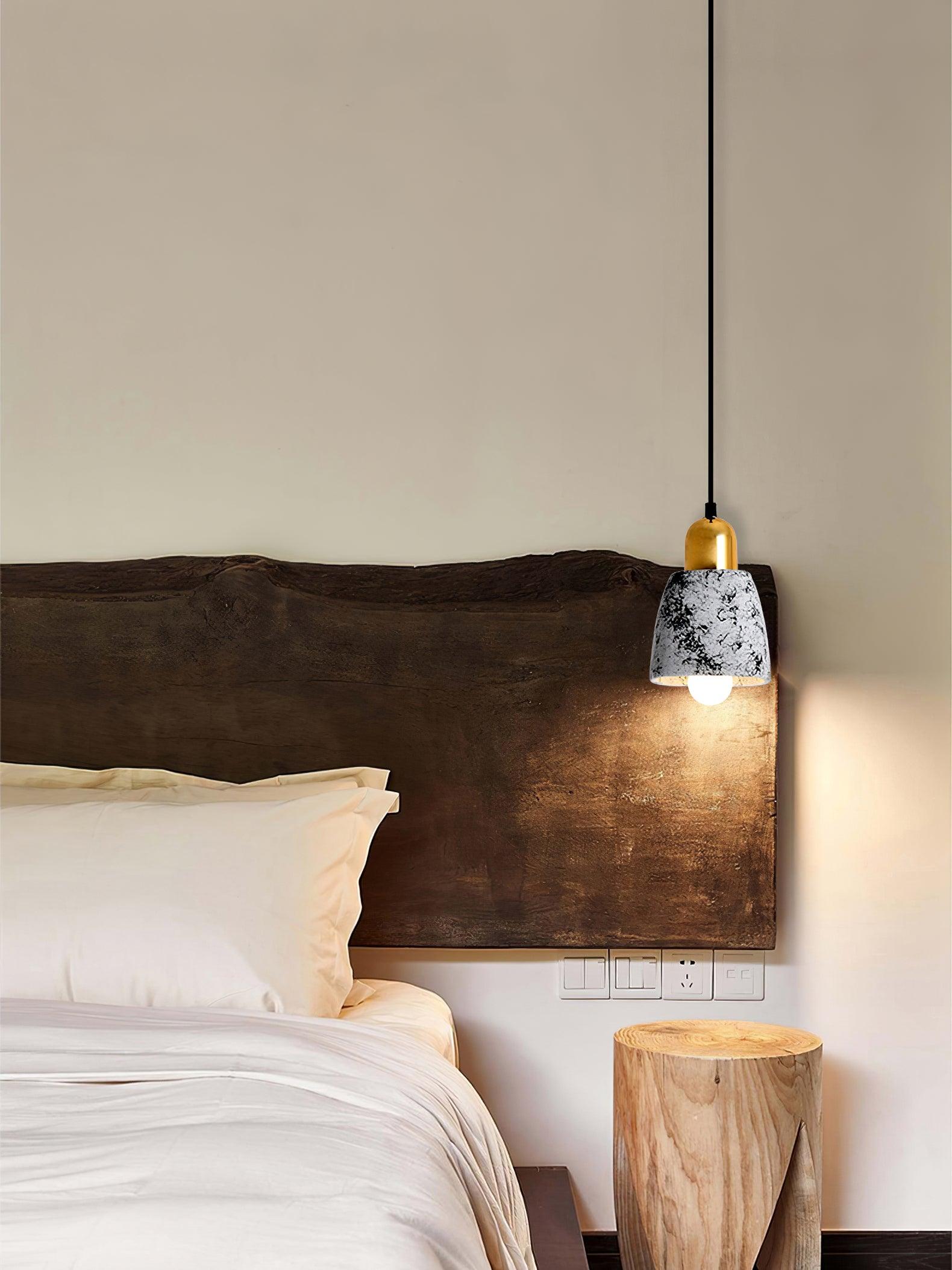 Small patterned cement pendant by a wooden headboard
