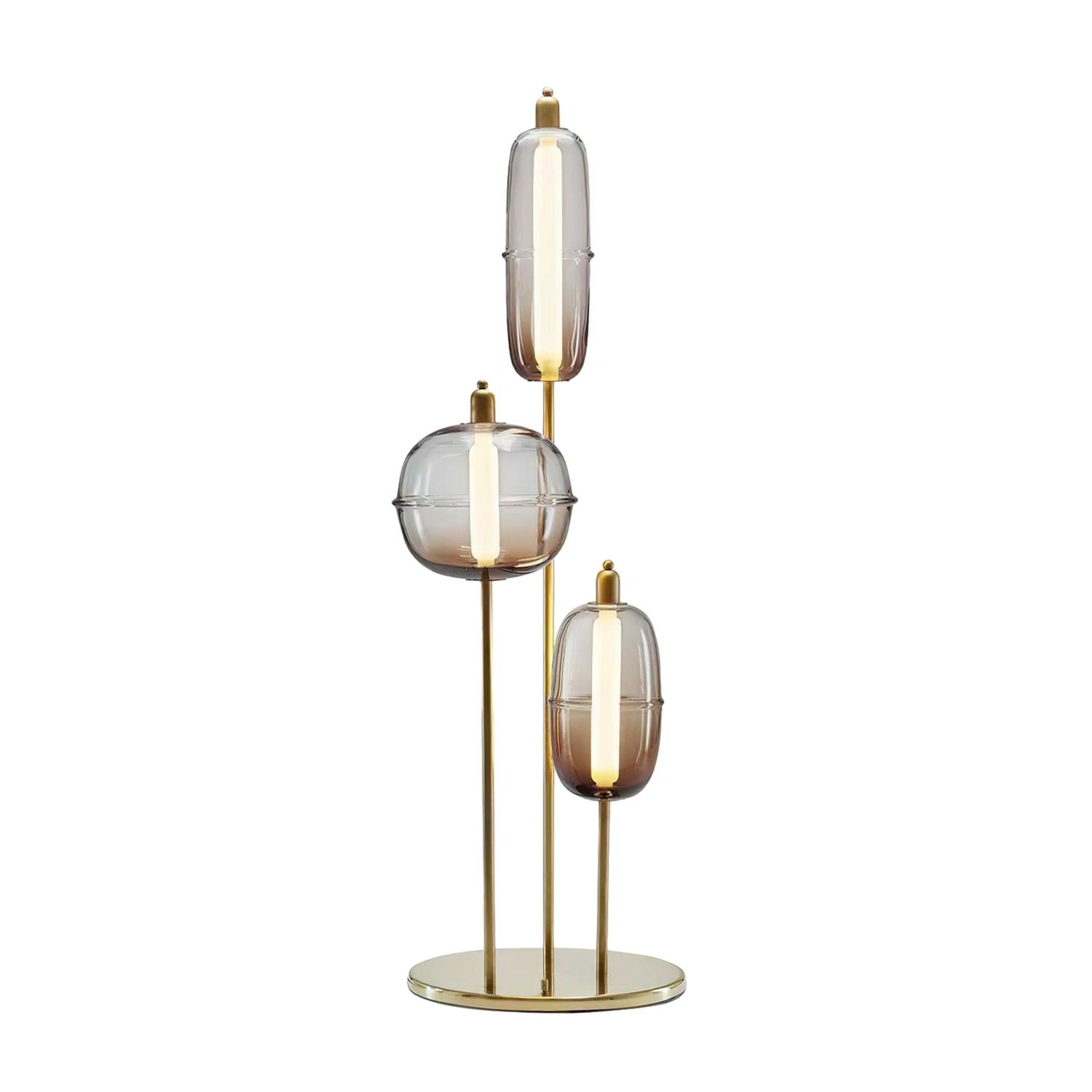 Smoke gray glass option with three staggered shades, pale vertical light cores, gold stems and a circular base