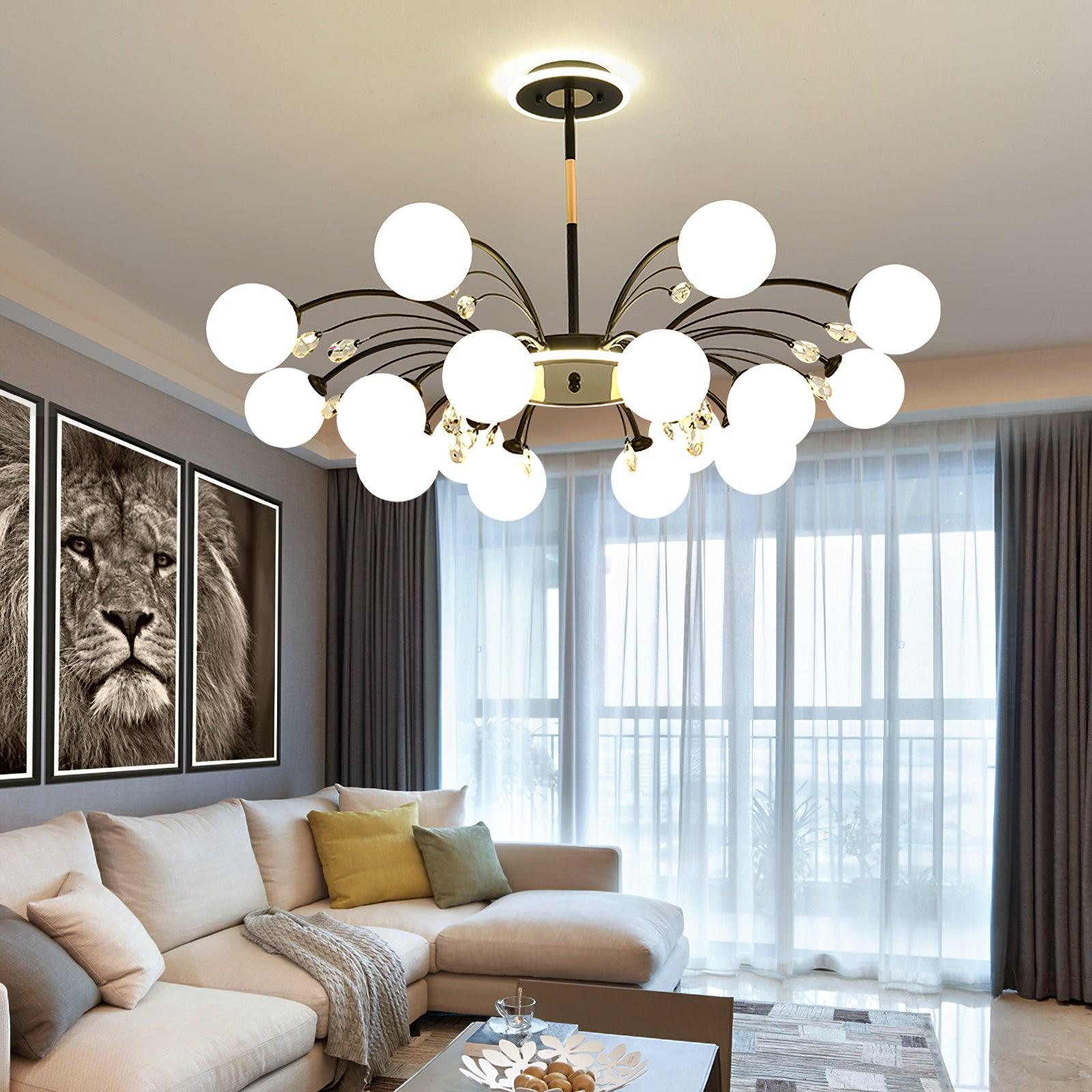 Black globe and clear-drop chandelier above cream sectional sofa, green and mustard cushions, lion prints and curtained window