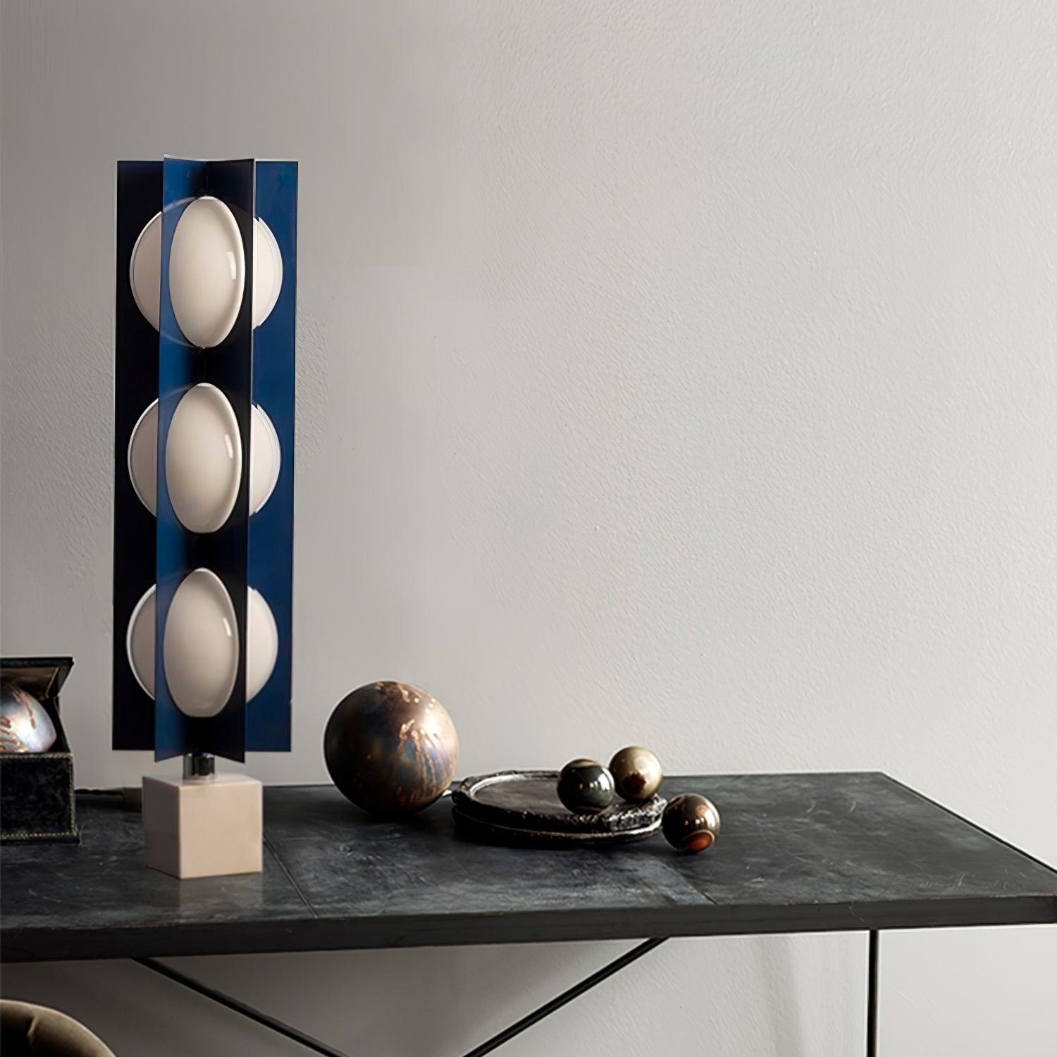 Closer three-level Cascade Tower on a dark console beside decorative spheres and a round tray