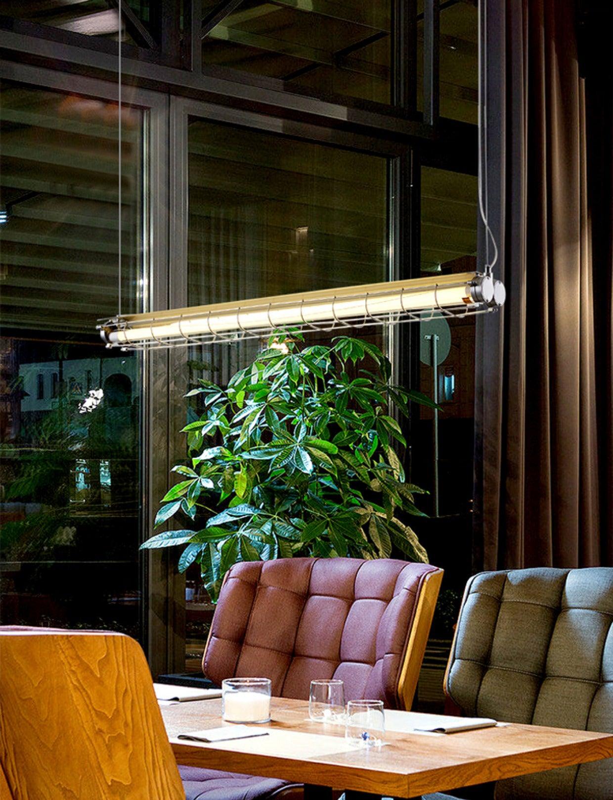 Artisan Glass chandelier above a cafe table beside tufted seating and a tall leafy plant