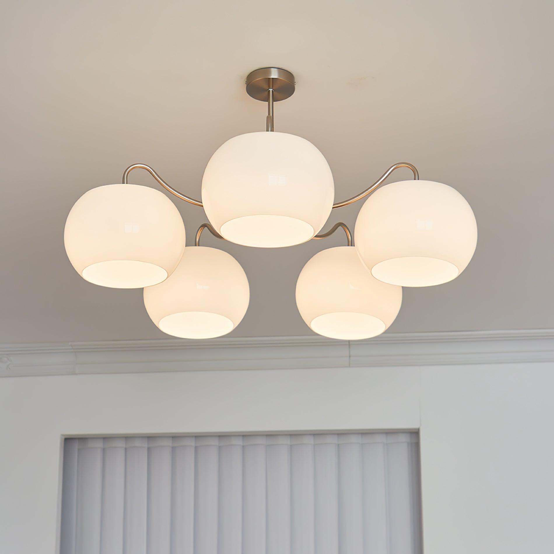 Persimmon chandelier with white glass shades and curved nickel-tone arms