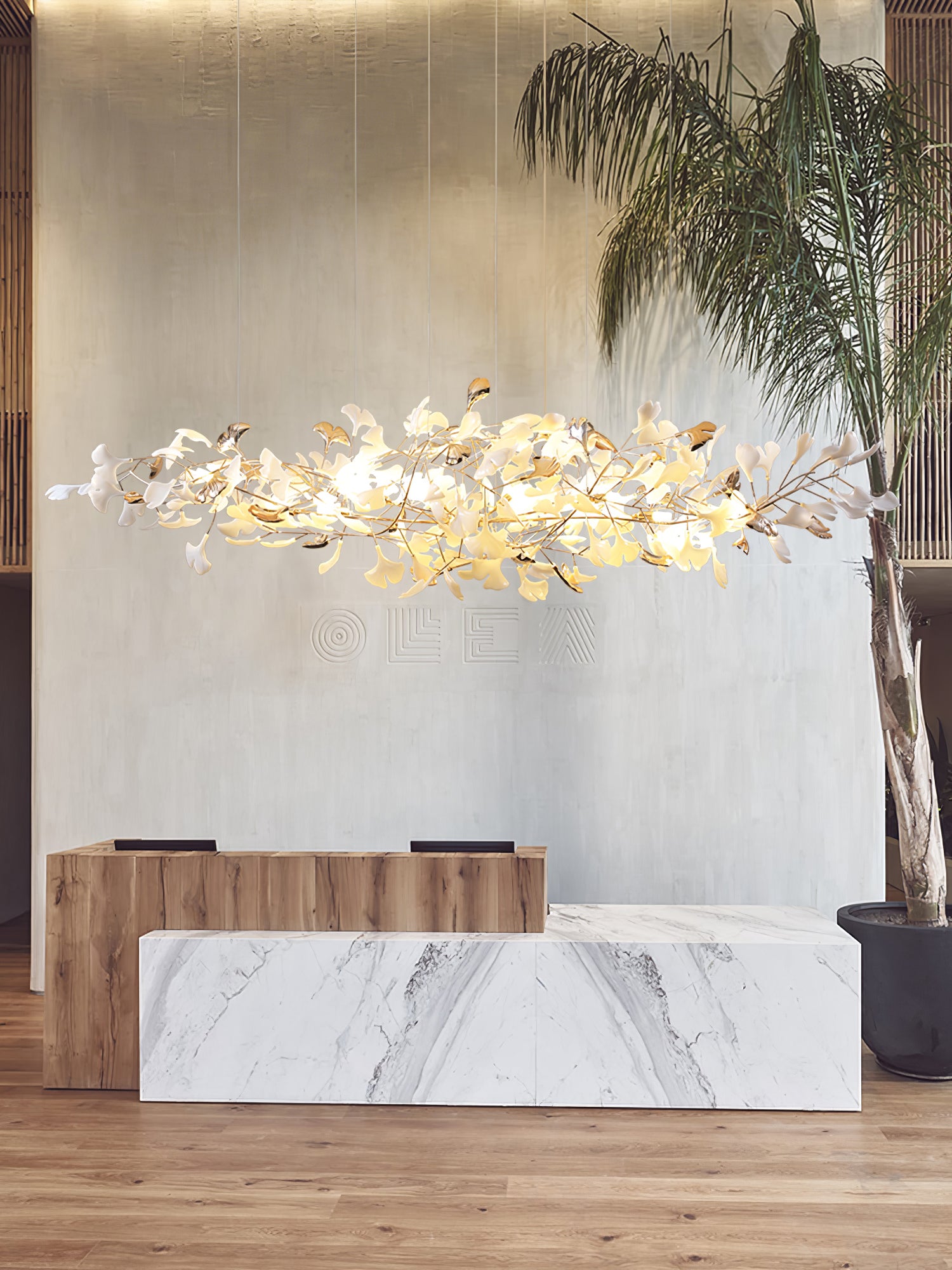 Portrait view of horizontal ginkgo leaf cloud over wood-and-marble counters with pale wall and potted palm