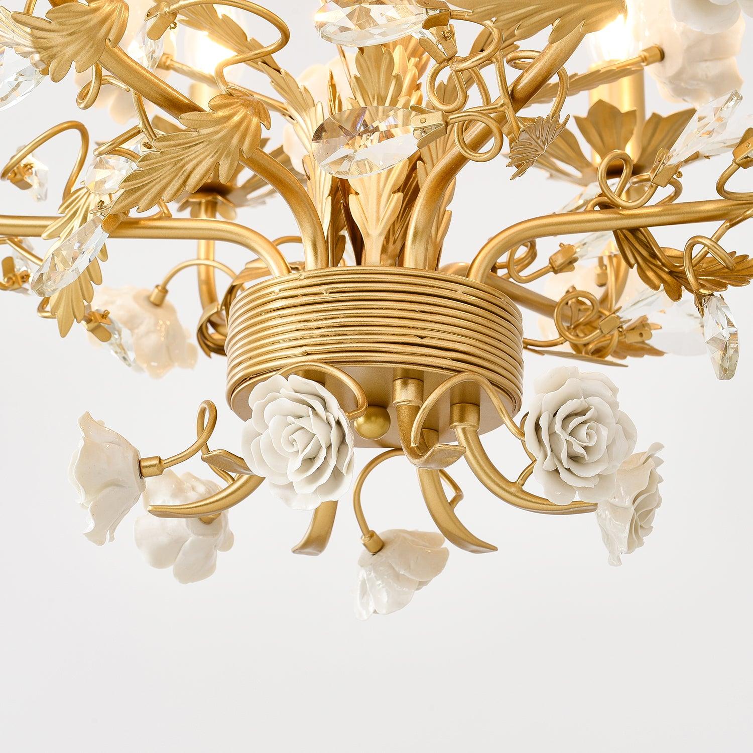 Underside detail of ribbed gold-tone hub with curling branches, white ceramic roses, golden leaves and clear crystal buds