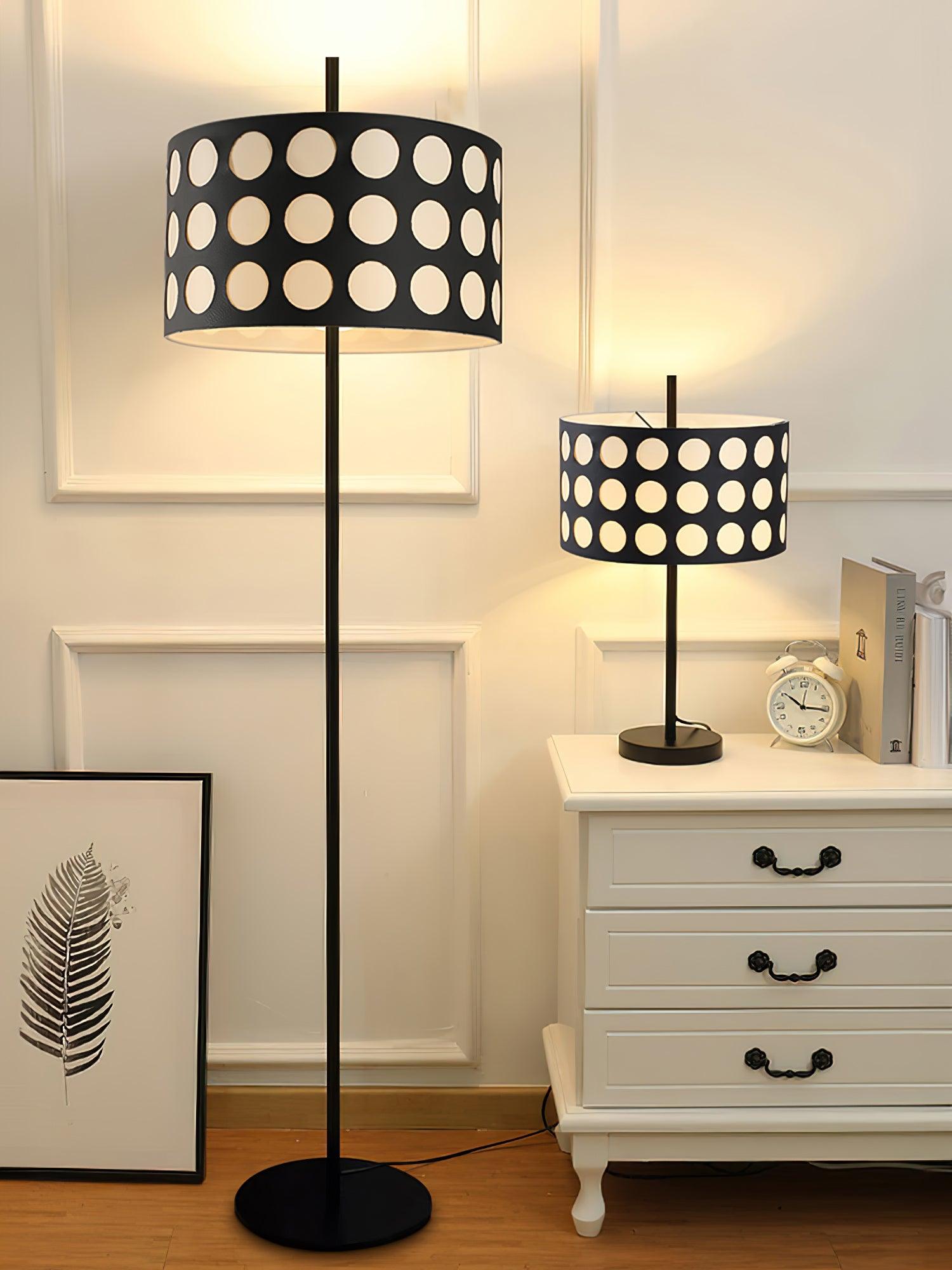 Straight dotted-shade floor lamp and smaller table lamp on white dresser beside clock and framed print