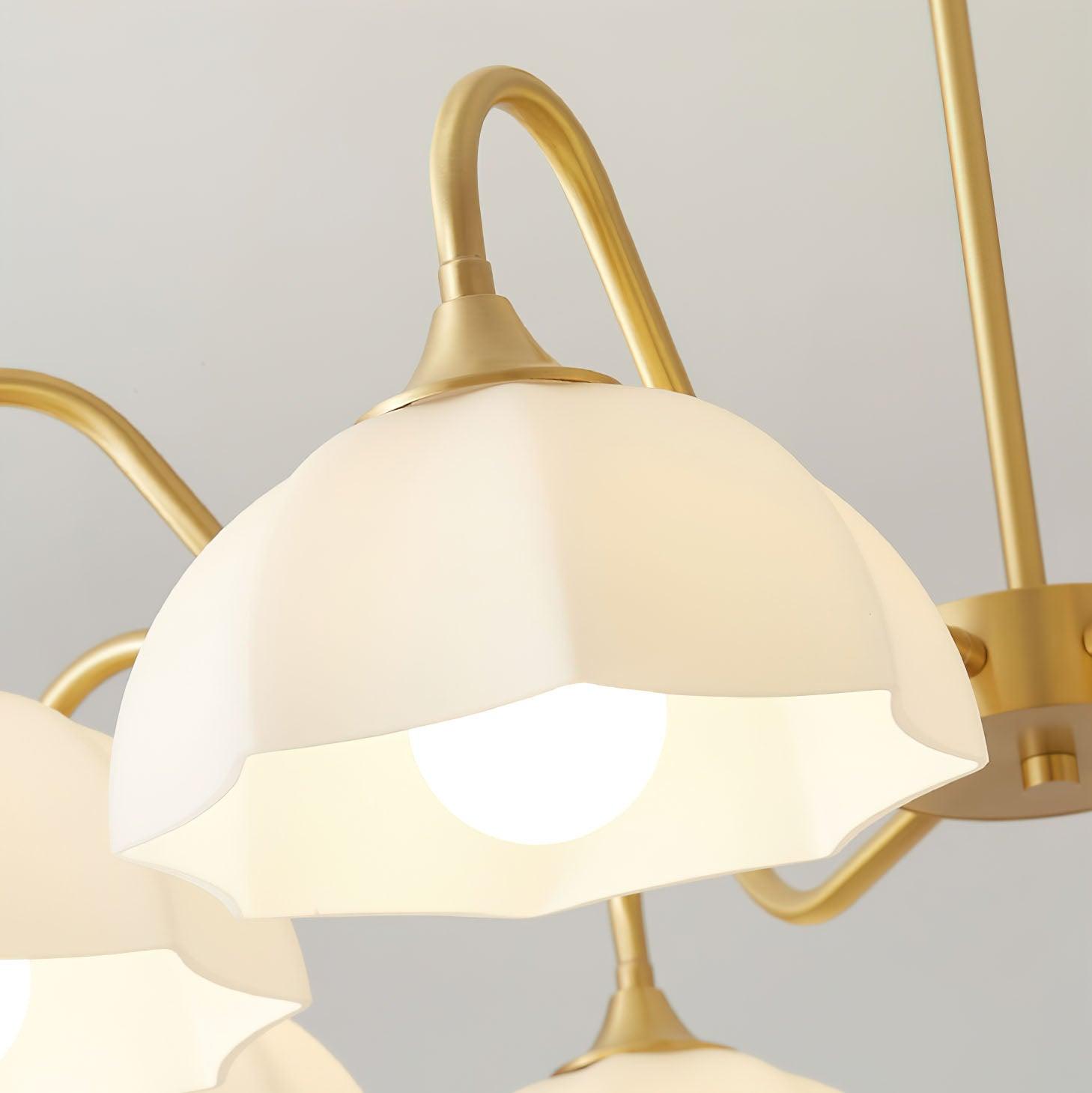 Close view of down-facing white glass shade and brass arm