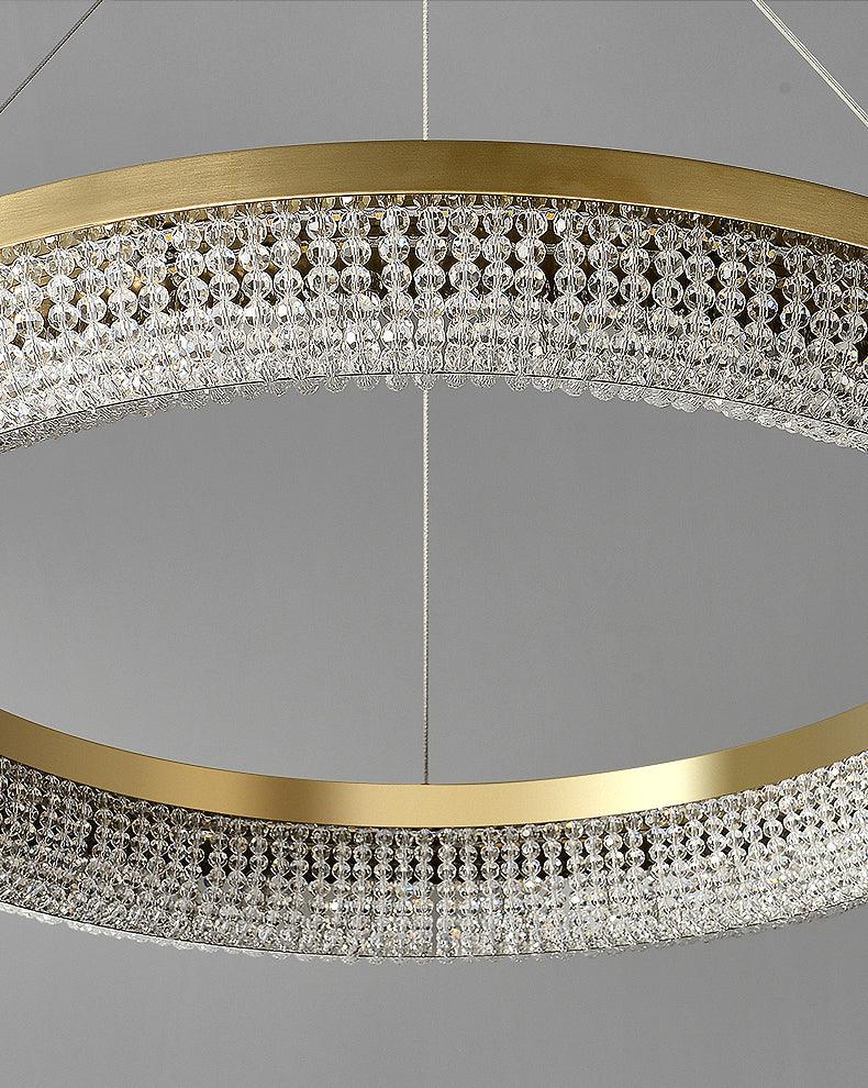 Unlit crystal ring close-up showing transparent faceted bead rows, gold rims and suspension wires