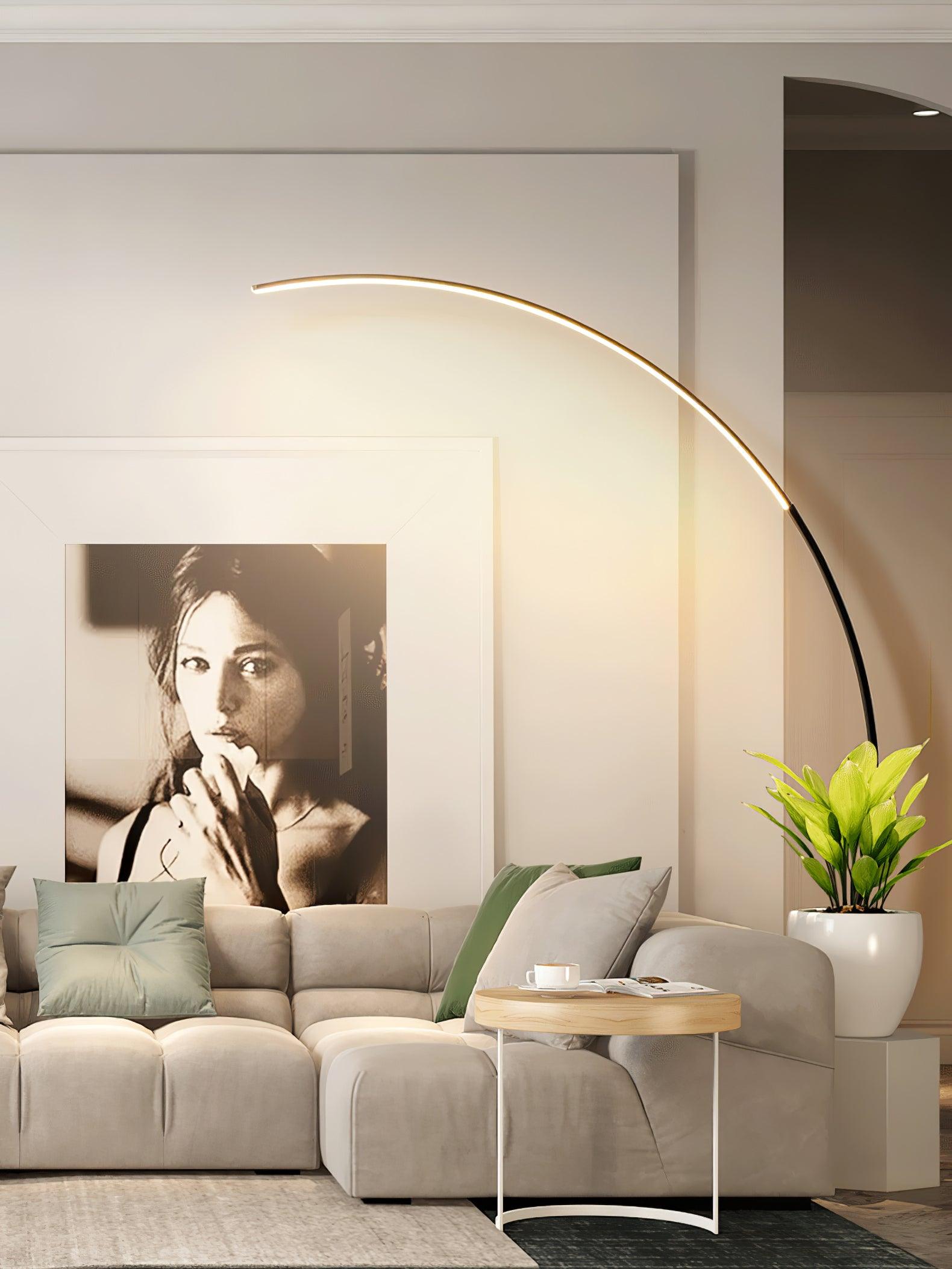 Black Arc floor lamp over cream sectional sofa and round wood side table, with large portrait and potted plant