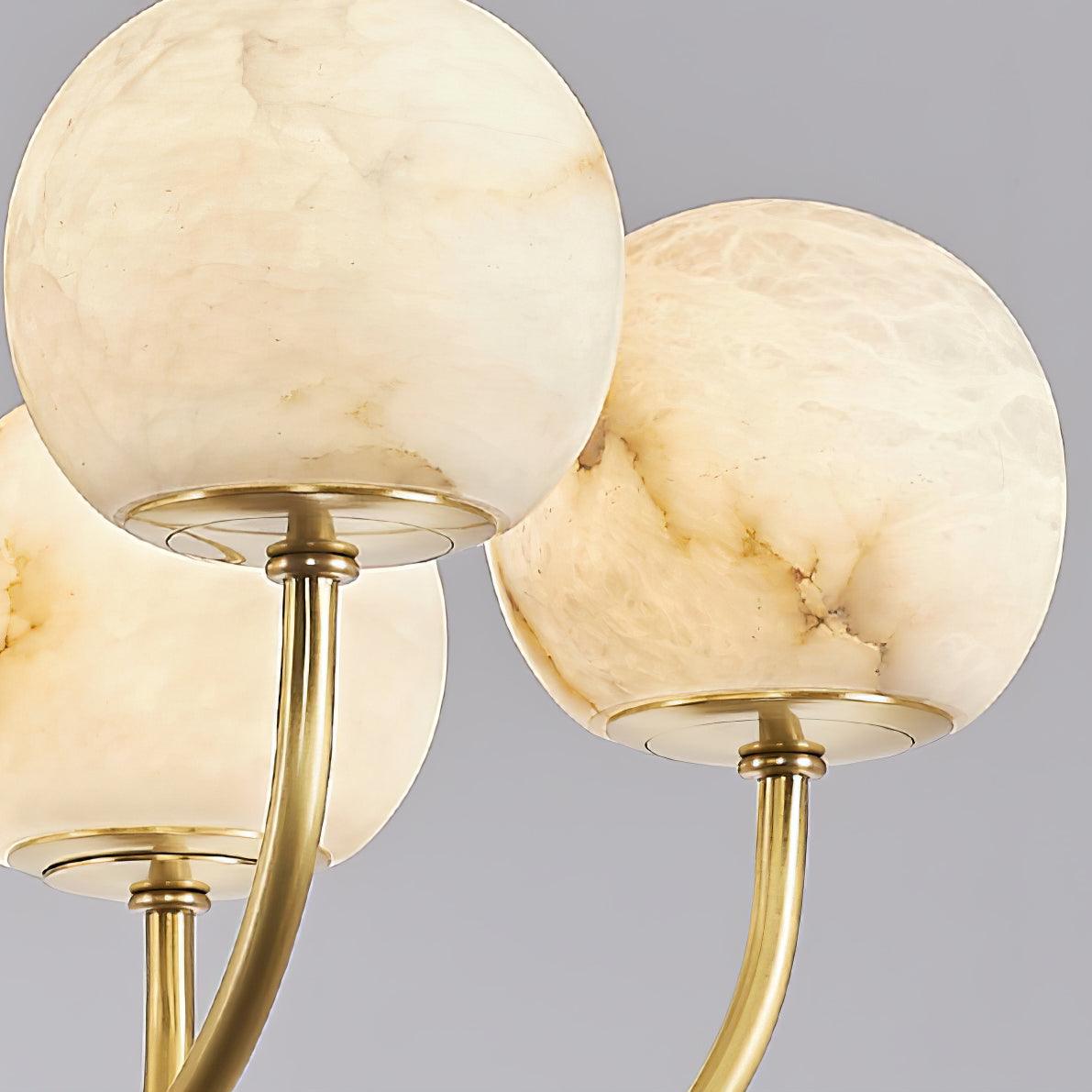 Close view of veined alabaster globes on brass arms
