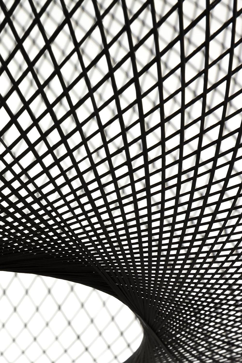 Extreme close-up of black mesh strands curving around the shade’s lower circular opening