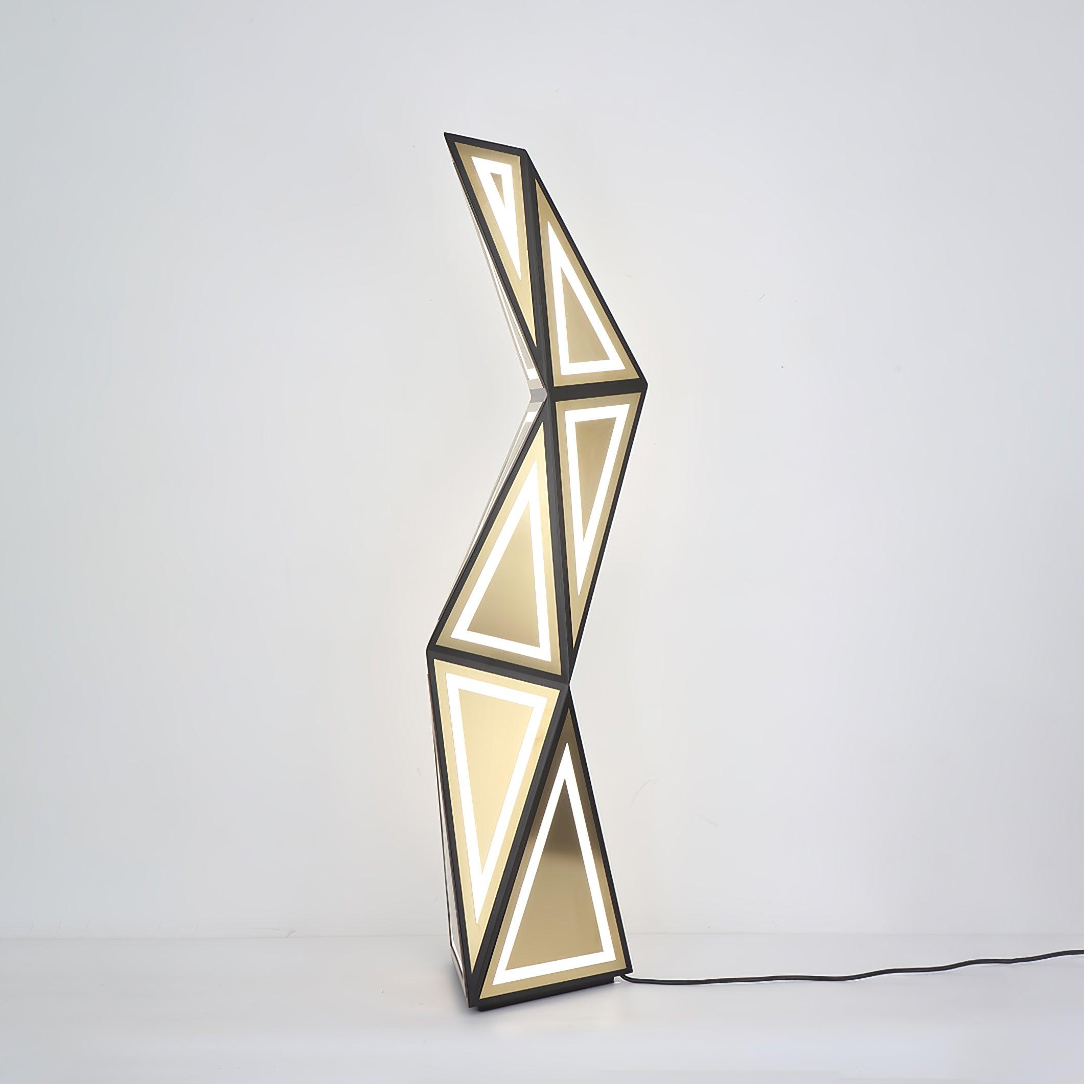 Black and gold faceted LED floor lamp on a pale background, showing triangular light outlines and black cord