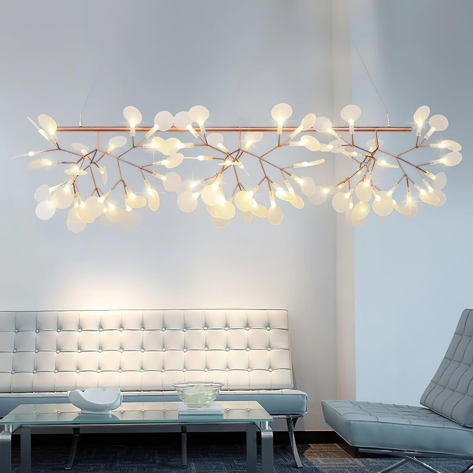 Illuminated rose-gold-colour branches above white tufted seating and glass coffee table with white bowls