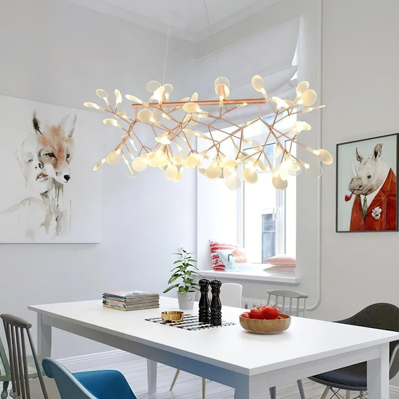 Rose-gold-colour petal chandelier above white table, pepper mills and bowl of red vegetables, with animal portraits
