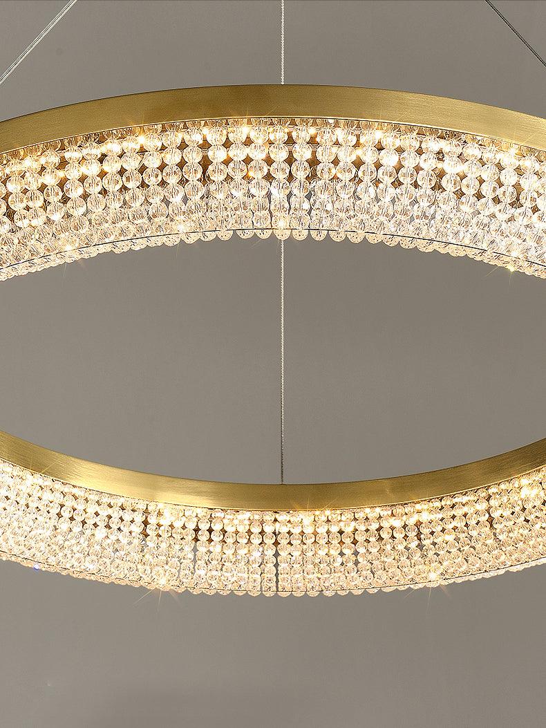 Illuminated single ring close-up with gold inner and outer rims and rows of clear faceted crystal beads