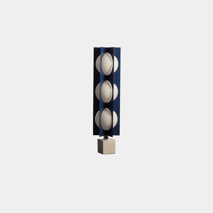 Distant isolated view of the three-level blue and white column lamp with its marble block base