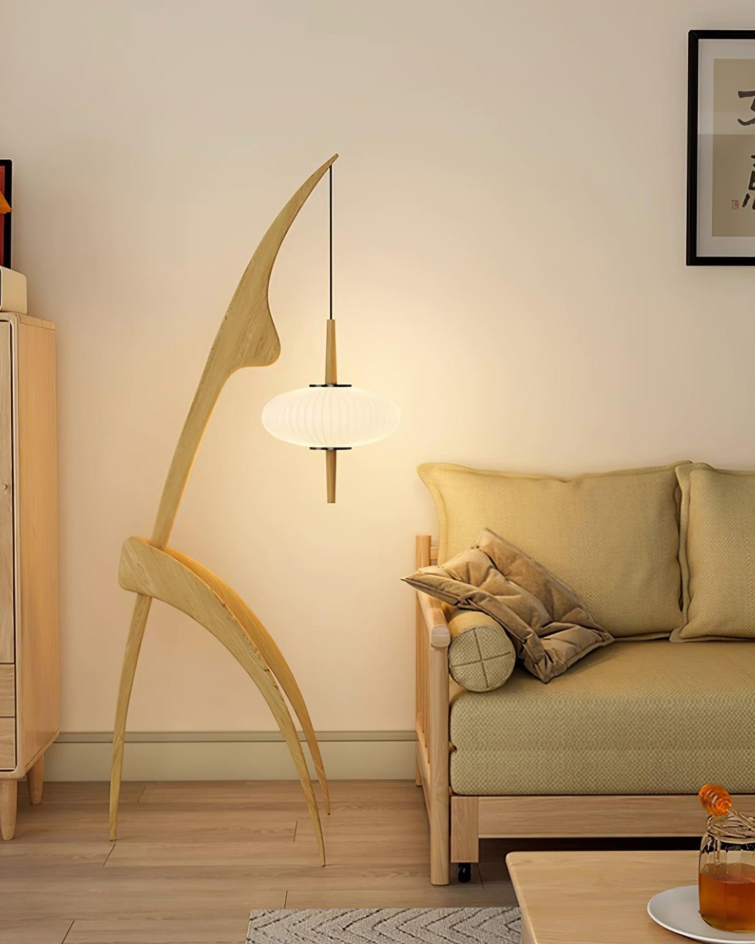 Light wood Mantis lamp illuminated beside a seating area