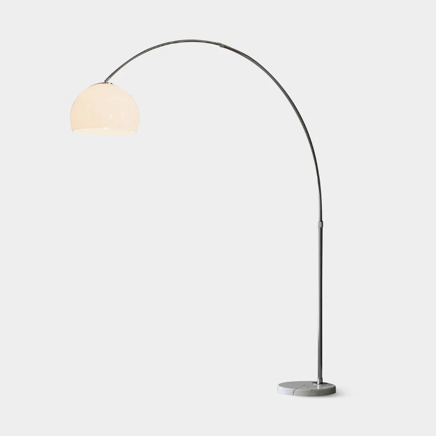 Lit white dome arc floor lamp with silver stem and round veined marble base, isolated against white