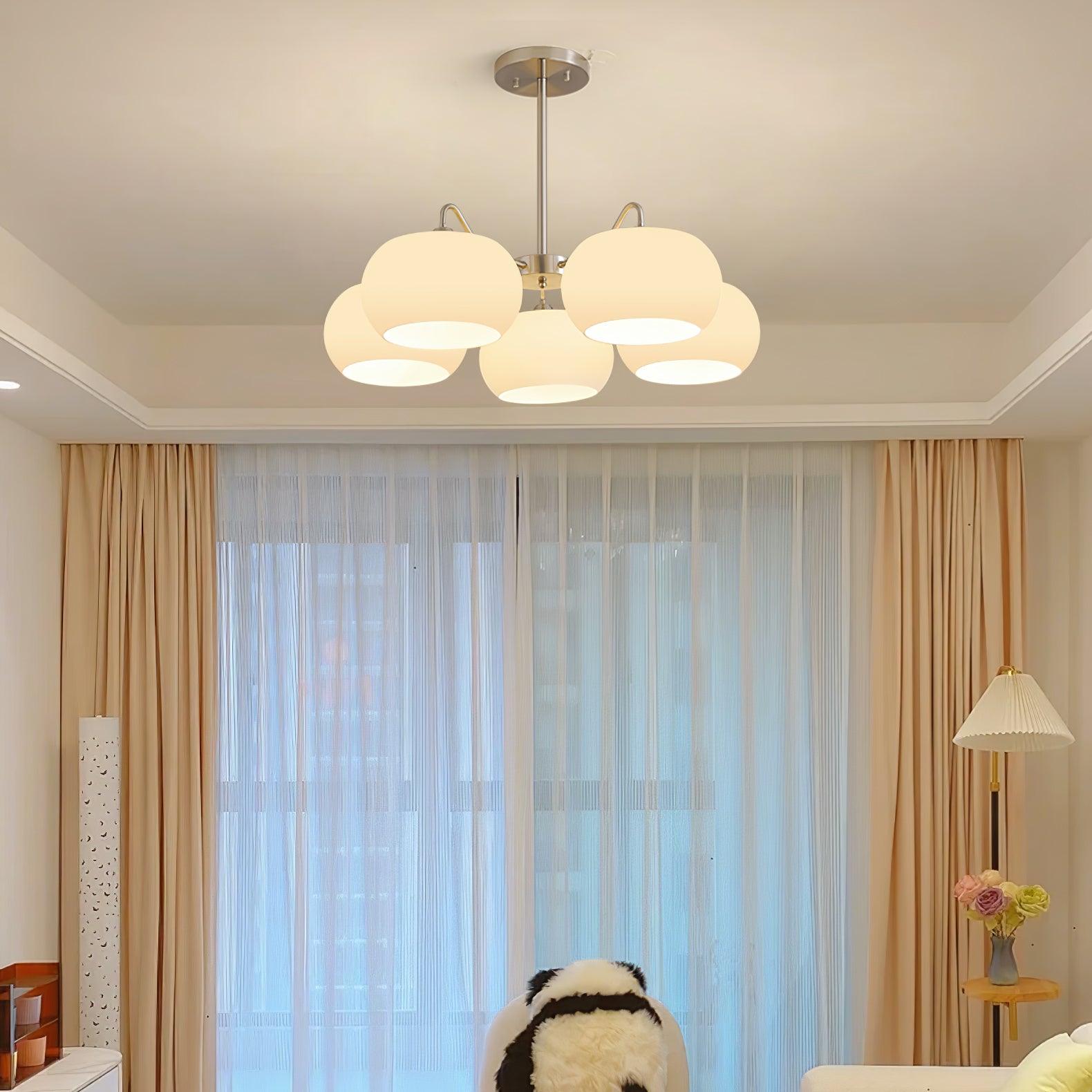 Persimmon chandelier with white glass shades and curved nickel-tone arms