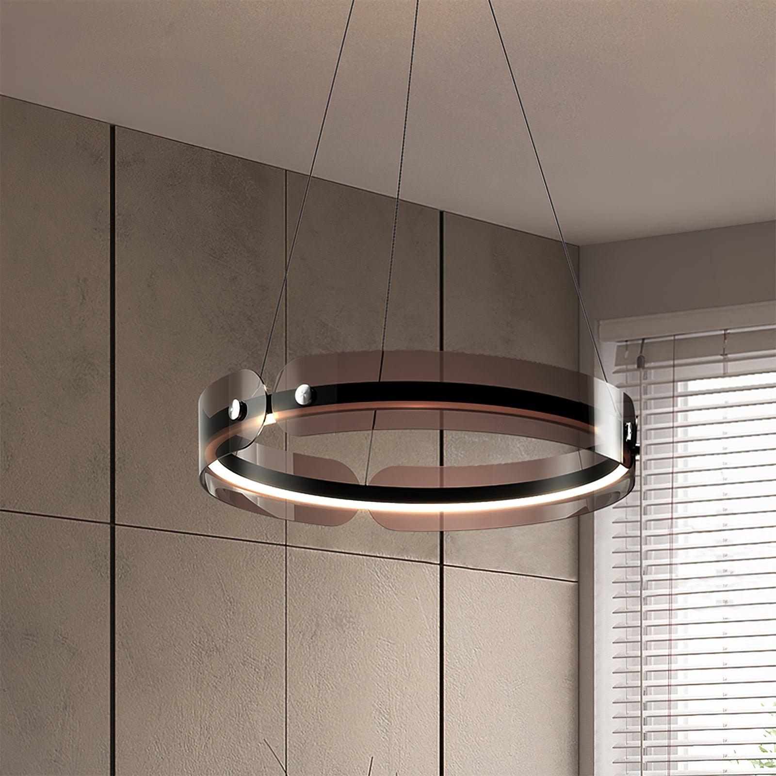 Close view of the lit Javor ring with coffee-tinted panels beside a beige wall and white window blinds