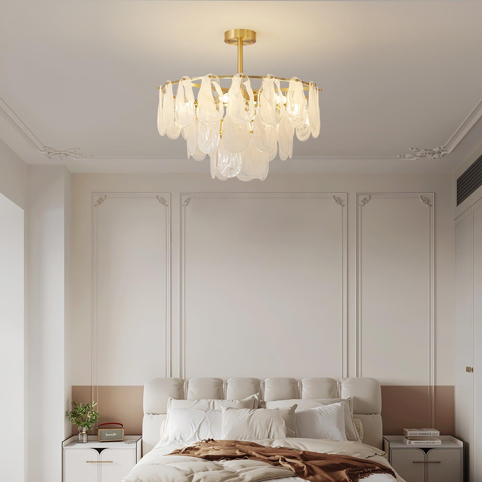 Layered Round Cloud glass pendant above a bedroom with a cream upholstered headboard