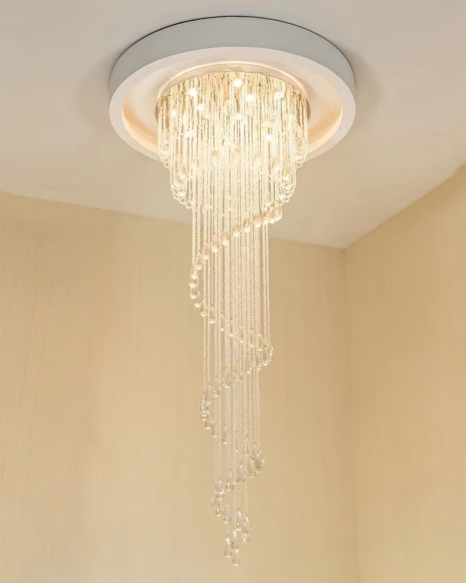 Lit crystal spiral beneath a broad circular architectural ceiling recess in a cream corner
