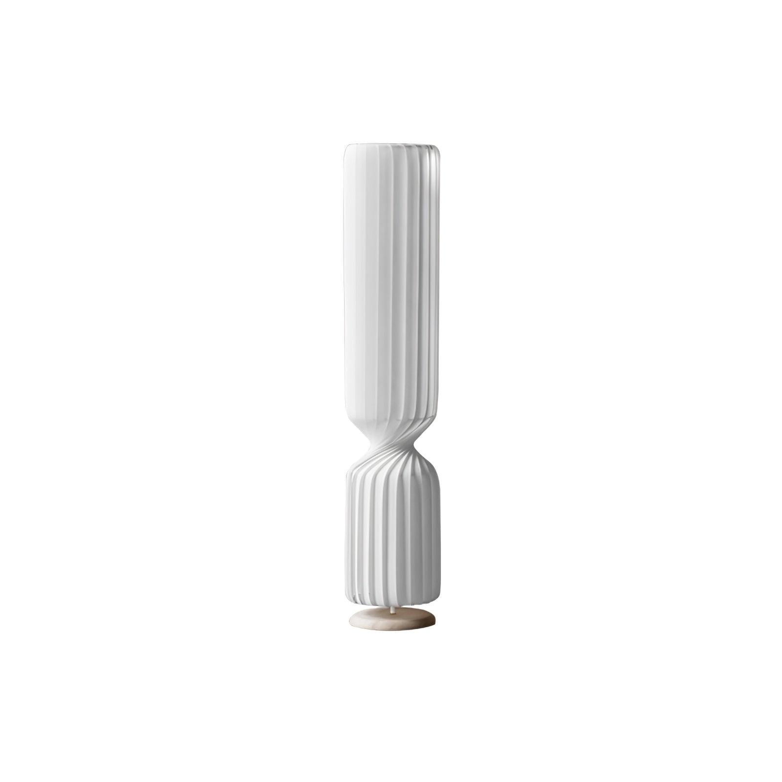 Mid-height white Twist lamp on white background, with long pleated upper section, twisted waist and pale circular base