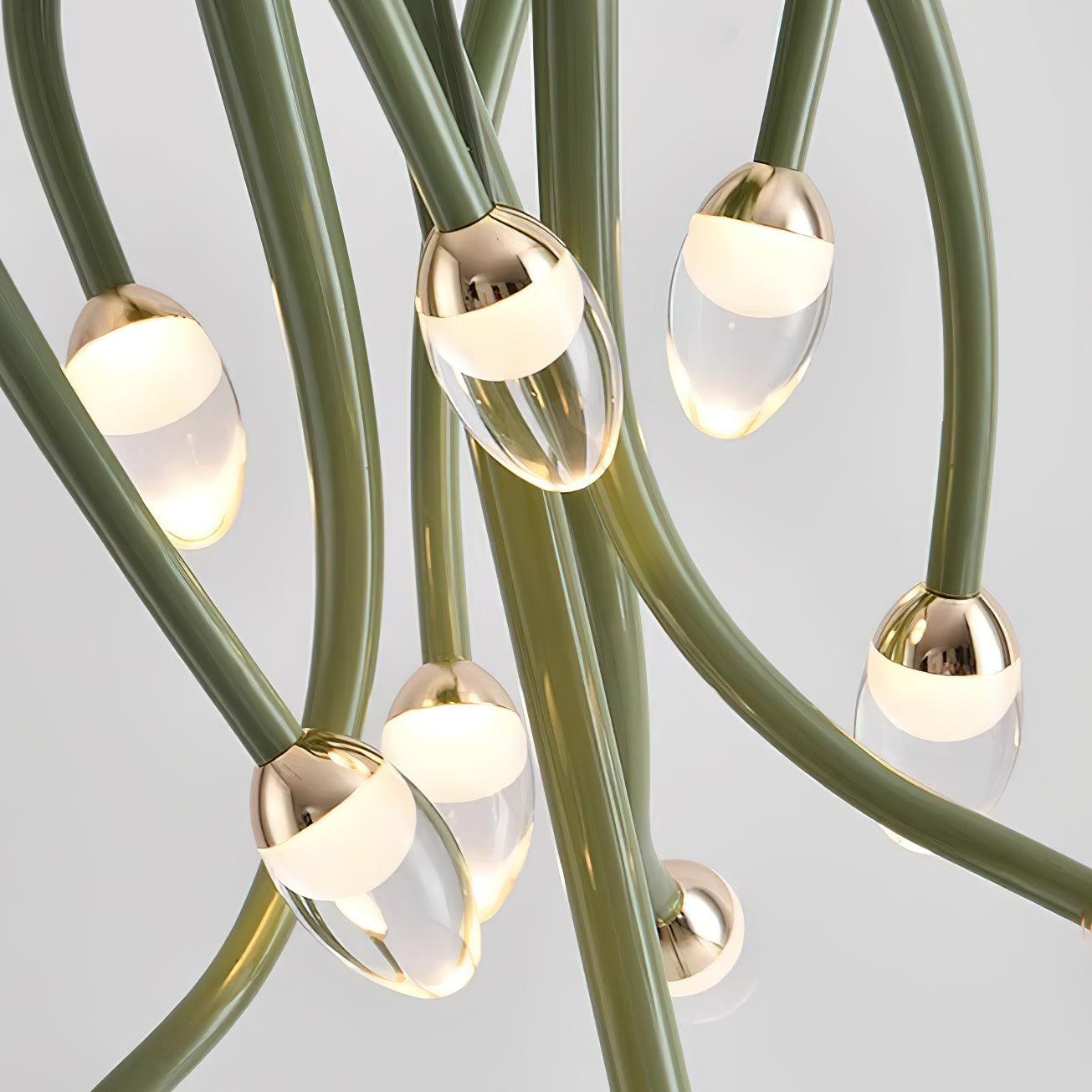 Close-up of curved green arms and clear droplet-shaped lights, with glowing pale interiors and gold-tone caps.
