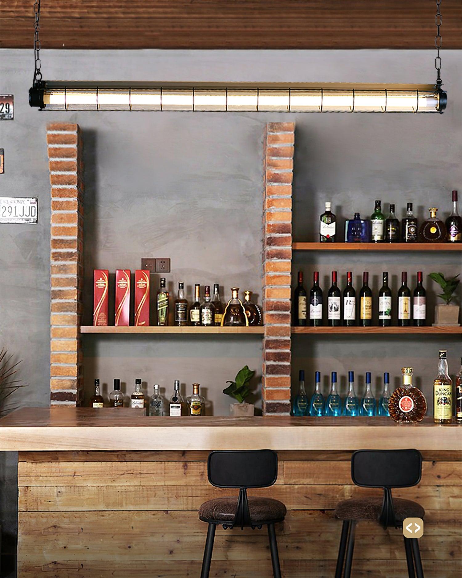 Artisan Glass chandelier above a bar with bottles, stools and a brick-framed wall opening