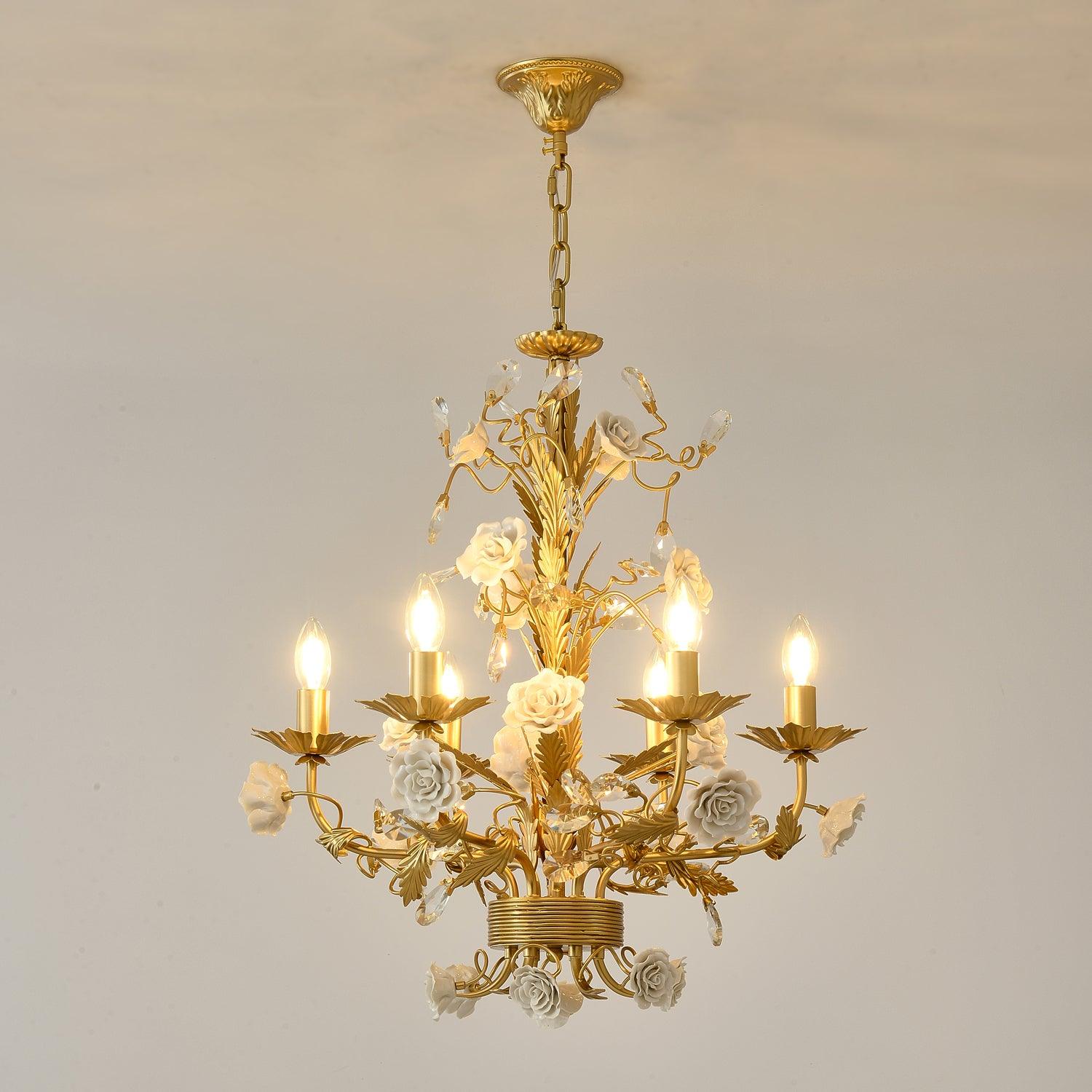 Portrait view of warm-lit White Rose chandelier on beige, showing complete canopy, chain, white roses and clear crystal buds
