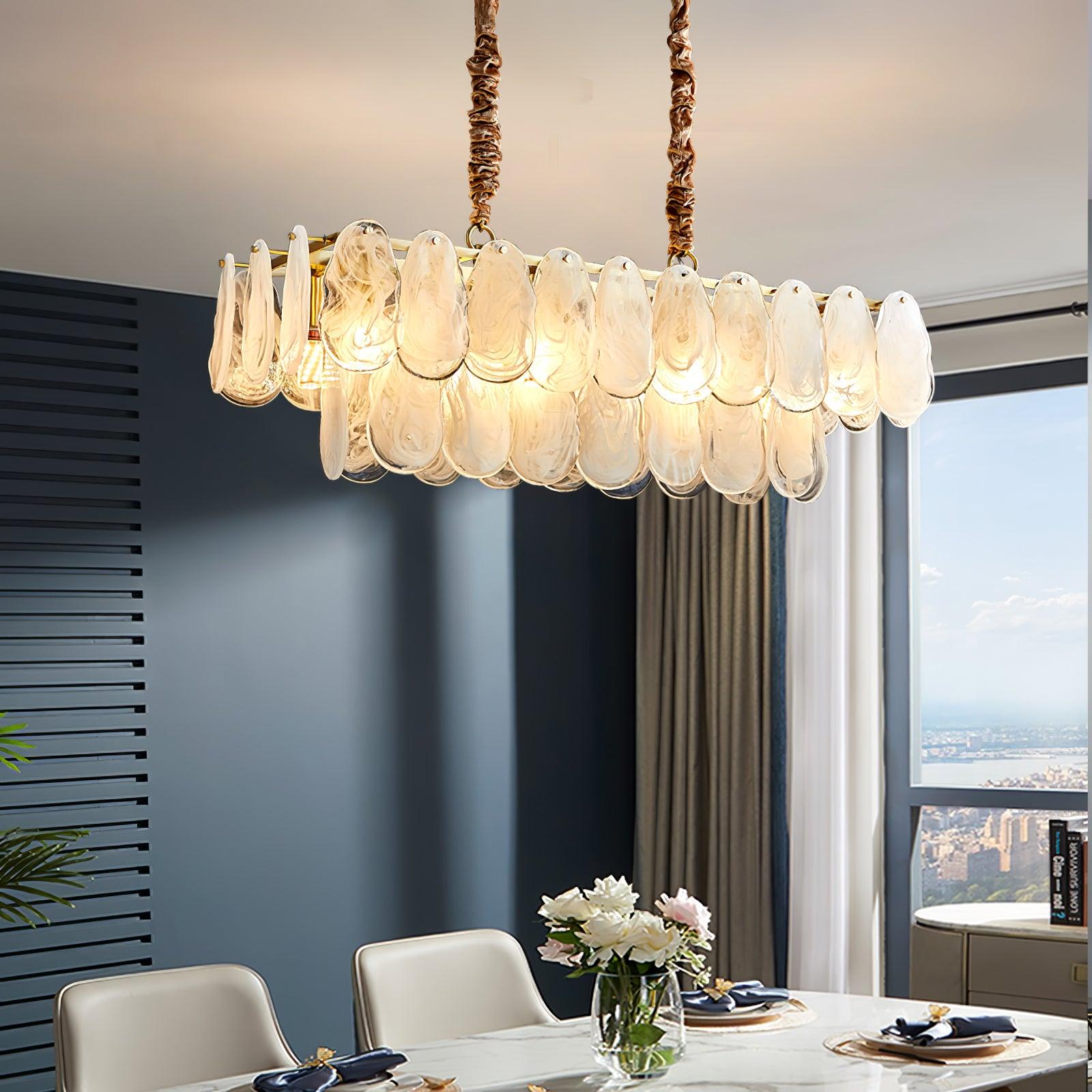 Linear Round Cloud glass pendant suspended above a dining table beside dark curtains